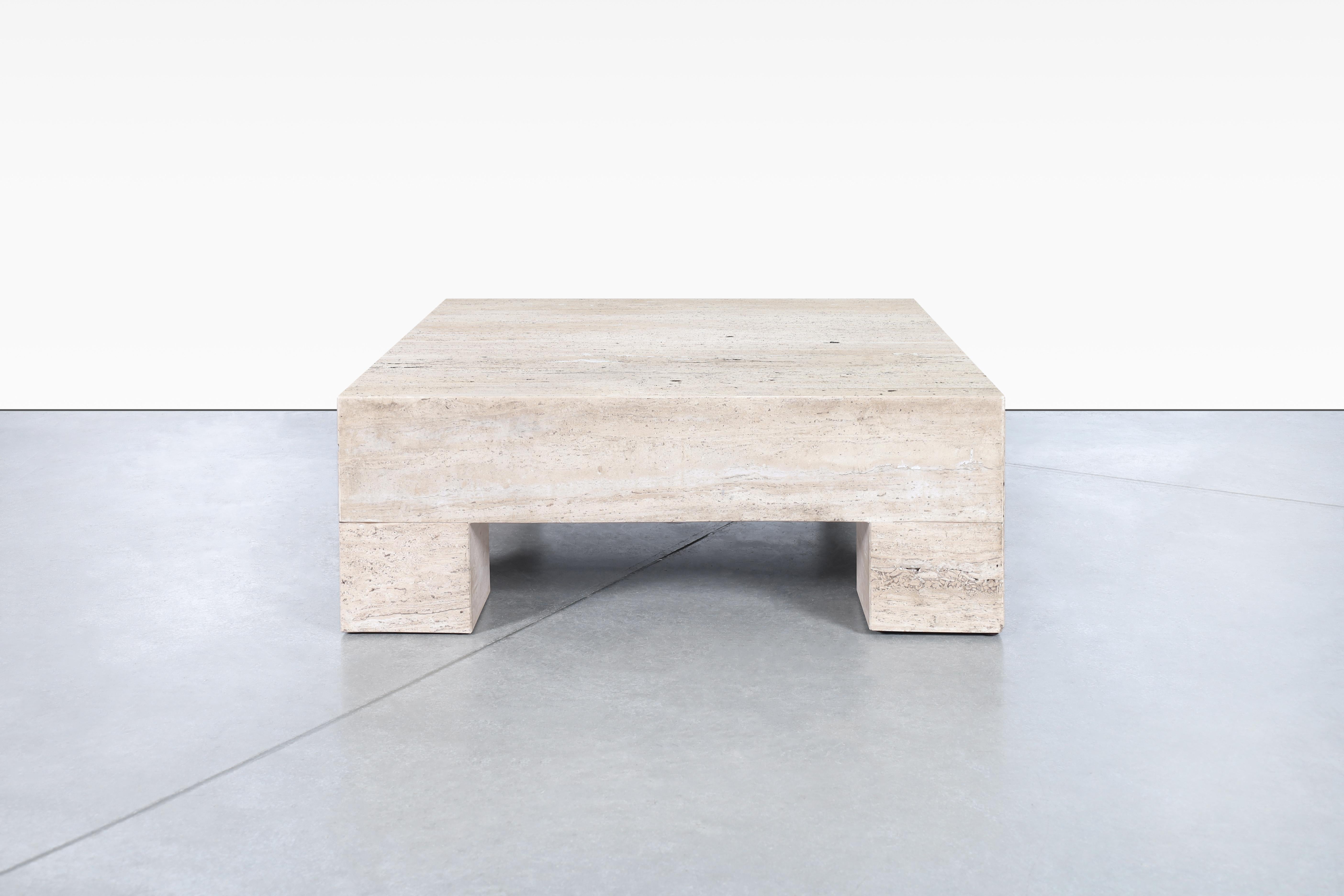 Vintage monumental Italian travertine coffee table designed in Italy, circa 1970s. The combination of the natural minerals that make up the travertine stone flows beautifully through the table. The table features a thick square travertine top and is