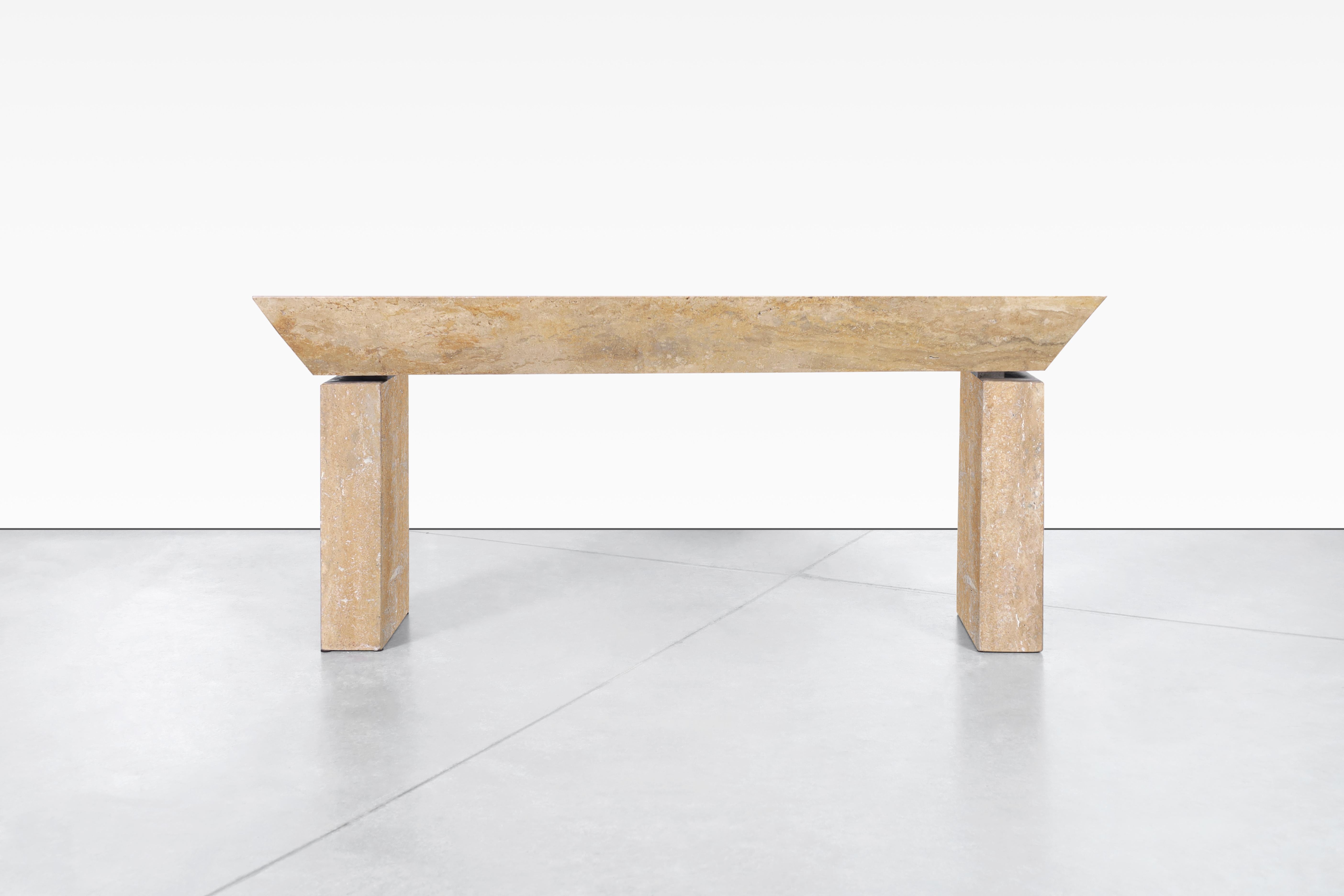 Vintage Italian travertine console table designed in Italy. The modernist design is perfectly complemented by the natural minerals of the travertine stone. The table features a rectangular travertine top with an angular cut around the entire edge