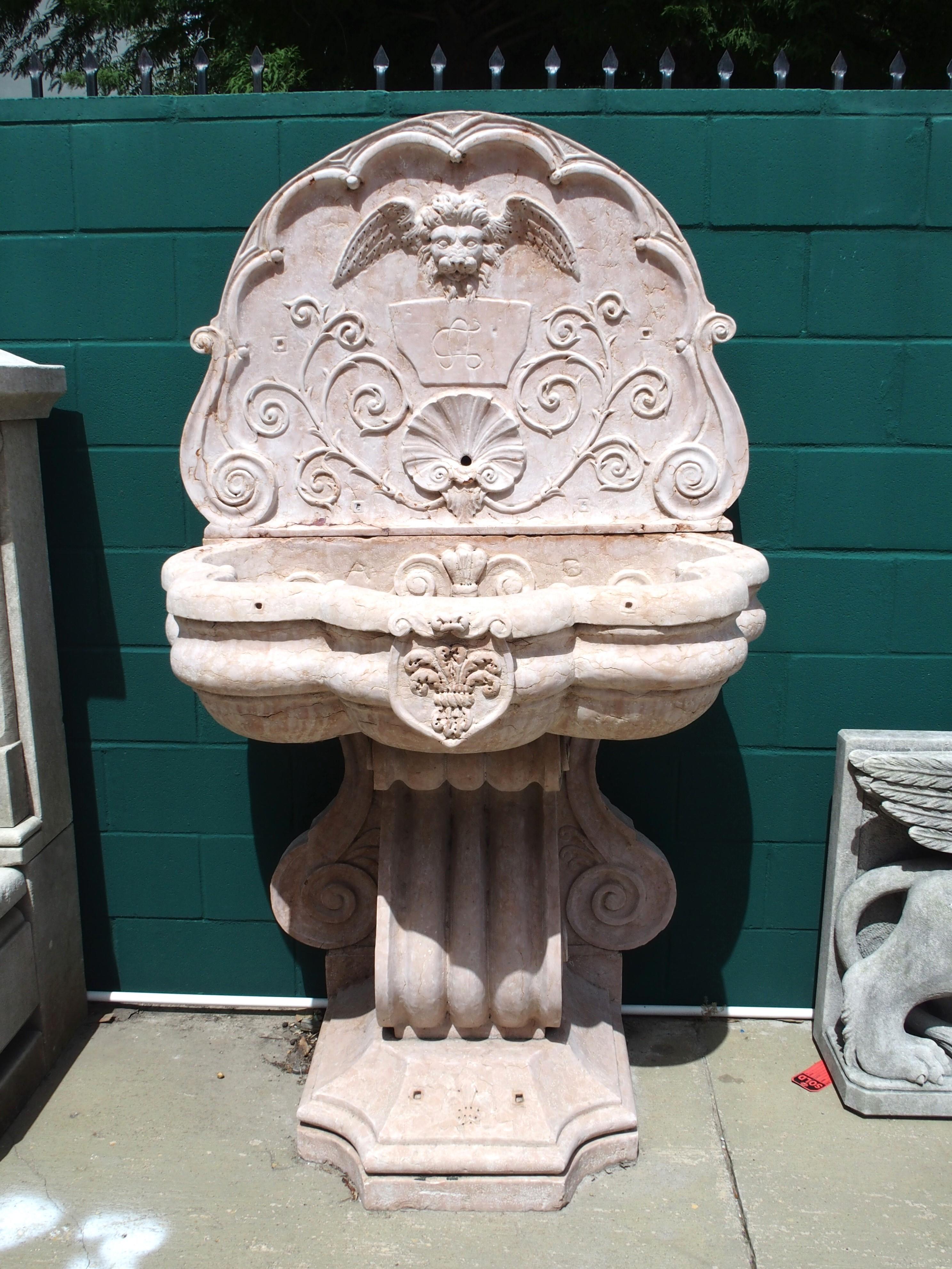Questa monumentale fontana a muro italiana è stata scolpita a mano in marmo rosso di Verona nei primi anni del 1900. Veramente opera di un maestro muratore, la fontana è composta da quattro spessi pezzi di marmo riccamente scolpiti, ognuno dei quali