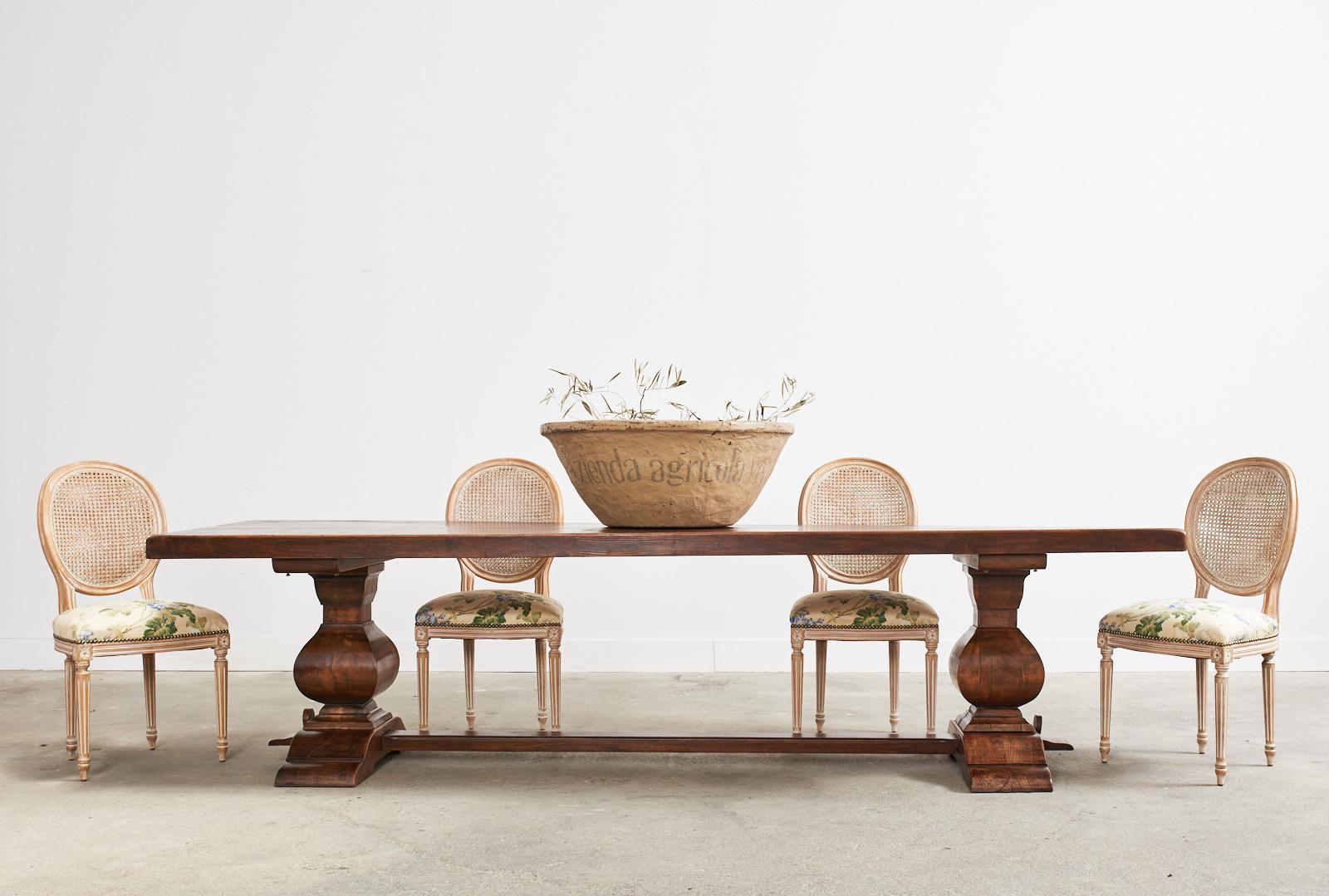 Rustic early 20th century monumental Italian monastery style dining table or refectory table crafted from walnut. The table features a large plank top measuring nearly three inches thick and almost 10 feet long. The table is supported by a large