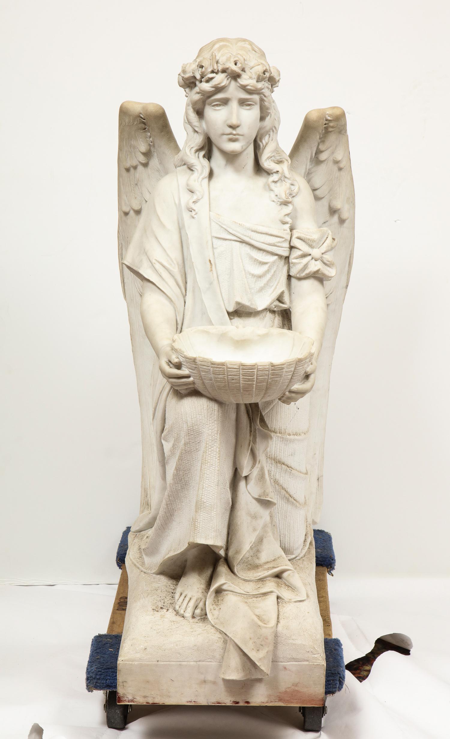 Monumental Italian white marble figure sculpture of a seated winged woman, Rome, 1870.

Depicting a seated female winged woman, holding a basket bowl on base.

Extremely finely carved by a master Italian sculptor.

Measures: 45