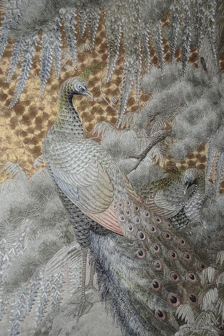 Als Teil unserer Sammlung japanischer Kunstwerke freuen wir uns, dieses herausragende großformatige Seidentextil aus der Meiji-Periode (1868-1912) anbieten zu können, das ein Paar Pfauen in einer Landschaft zeigt. Diese schönen Vögel ruhen an einem