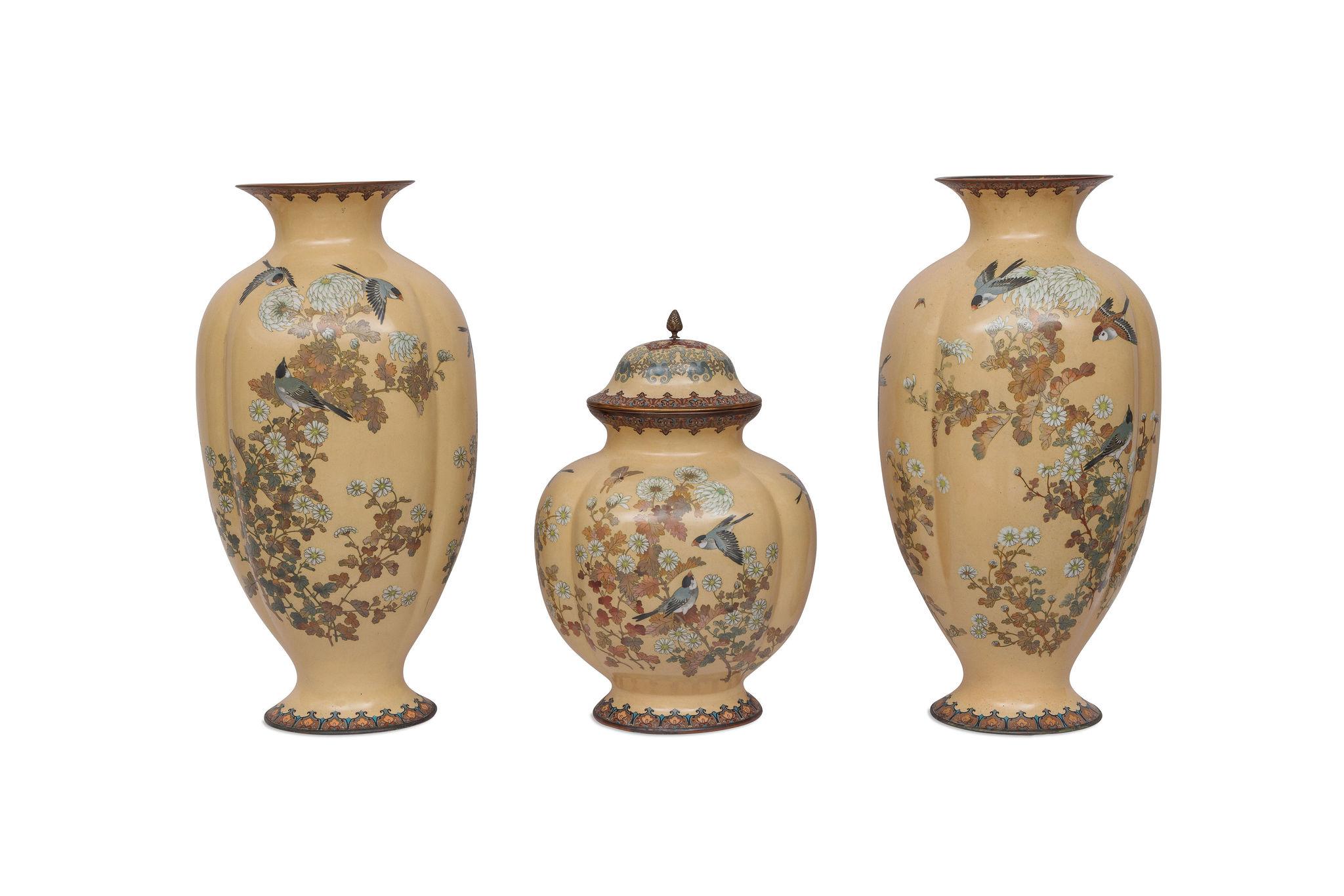 A Monumental Japanese Meiji Period Three-Piece Lobed Cloisonné Enamel Garniture with Birds, Butterflies, and Chrysanthemums on a Rare Pale Peach Ground, Attributed to the Nagoya Cloisonné Company

A monumental Japanese cloisonné enamel three-piece