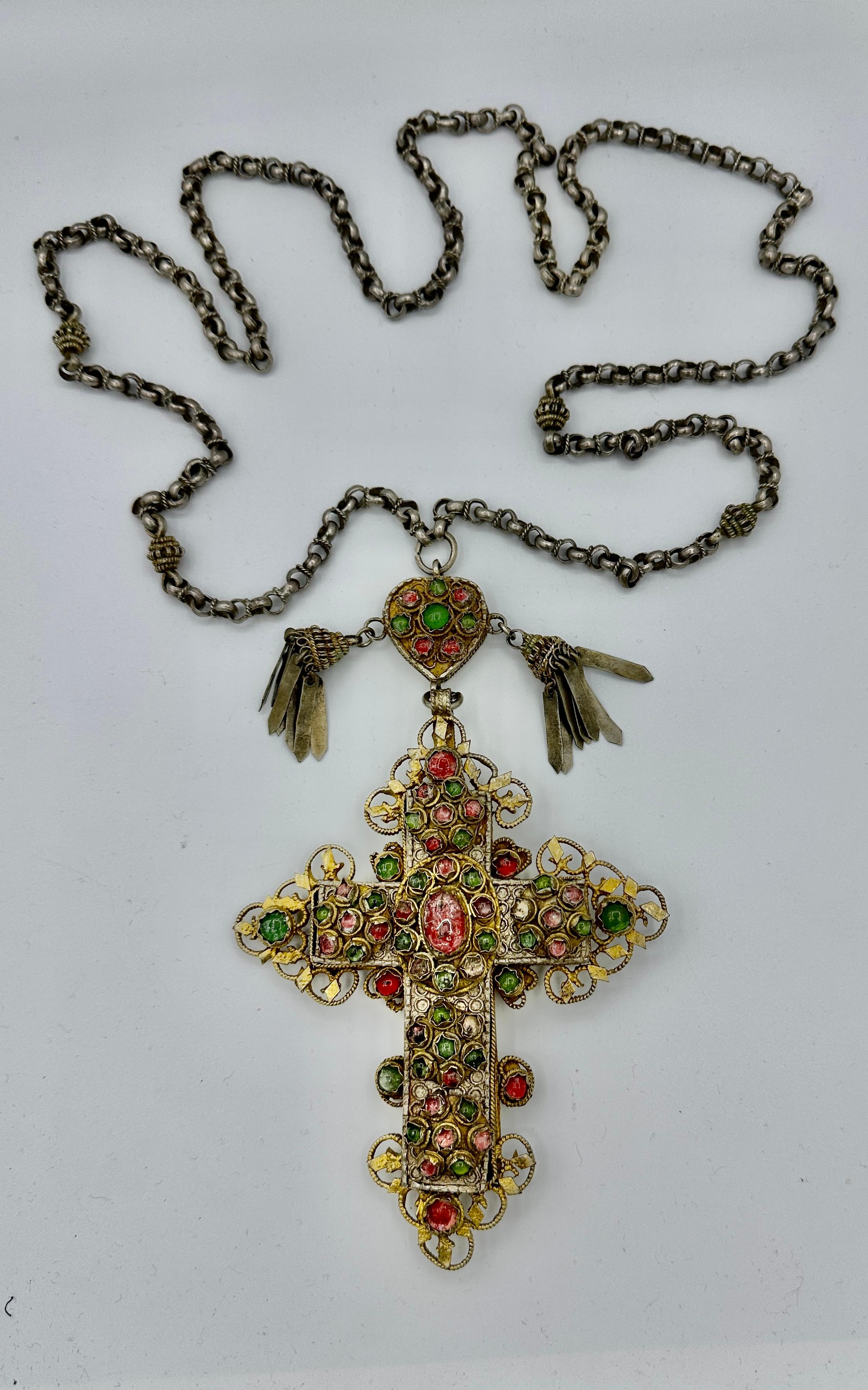 Indulge in a magnificent Museum Quality Antique Jeweled Orthodox Bishop Cross Necklace.  The extraordinary necklace features a 7 inch pendant of a bejeweled cross in Silver-Gilt with a Heart motif at the top adorned with pendant tassels. 
The heart