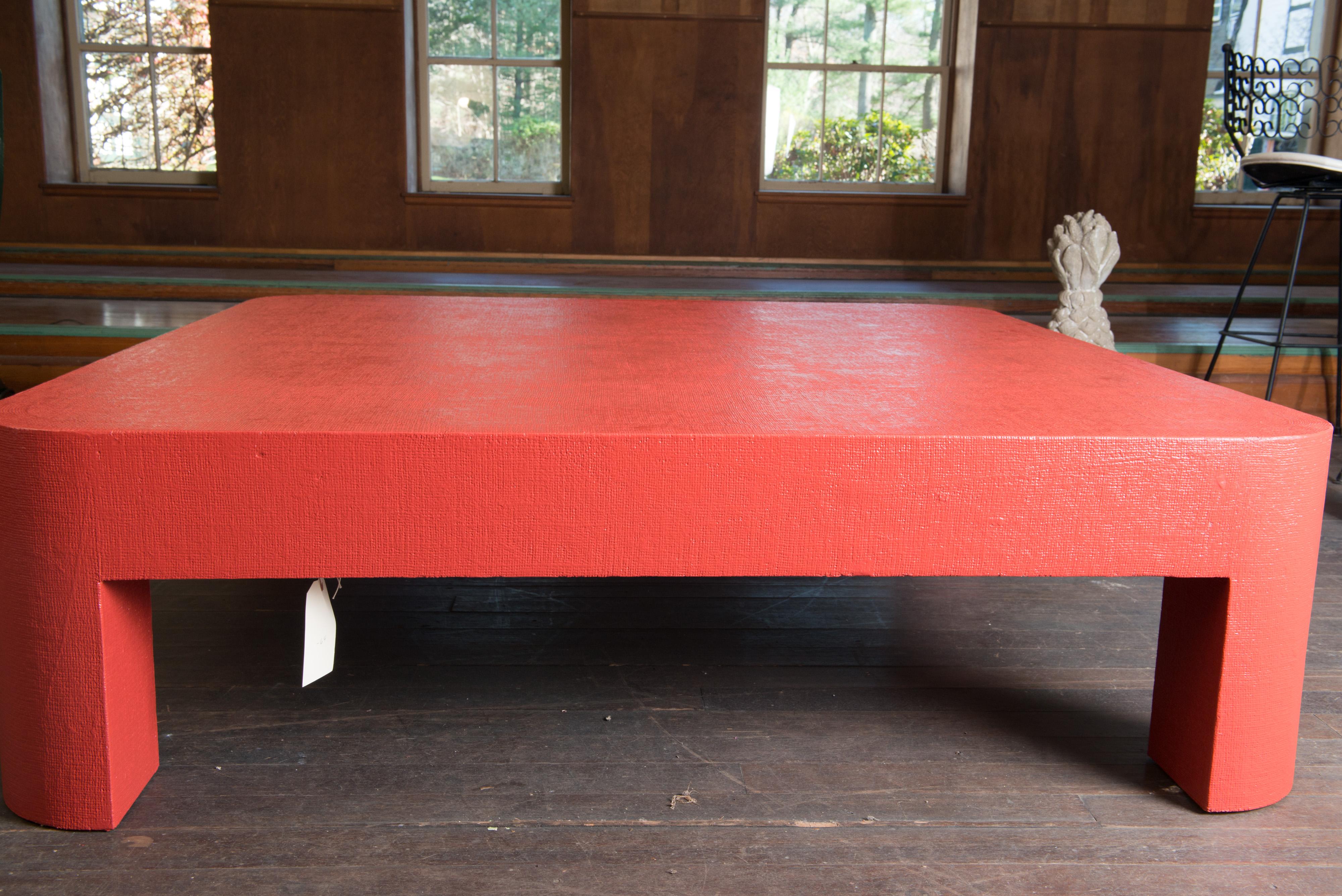 Red-orange painted grass cloth covered Karl Springer style square coffee table.