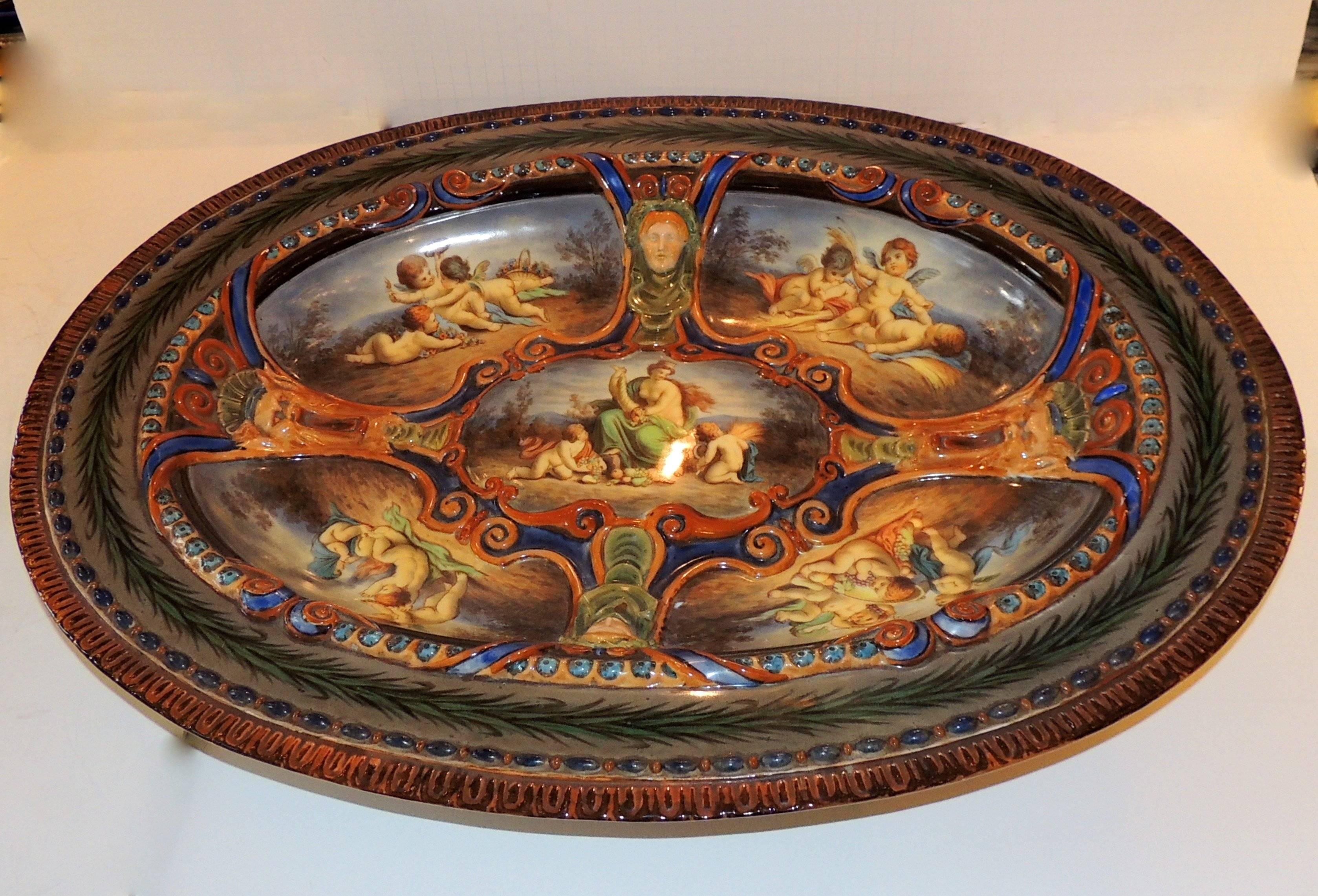 A wonderful and very fine presentation KPM monumental hand painted German Berlin porcelain oval centerpiece platter with five scenes adorned with cherub’s female and male masks.
Very rare!