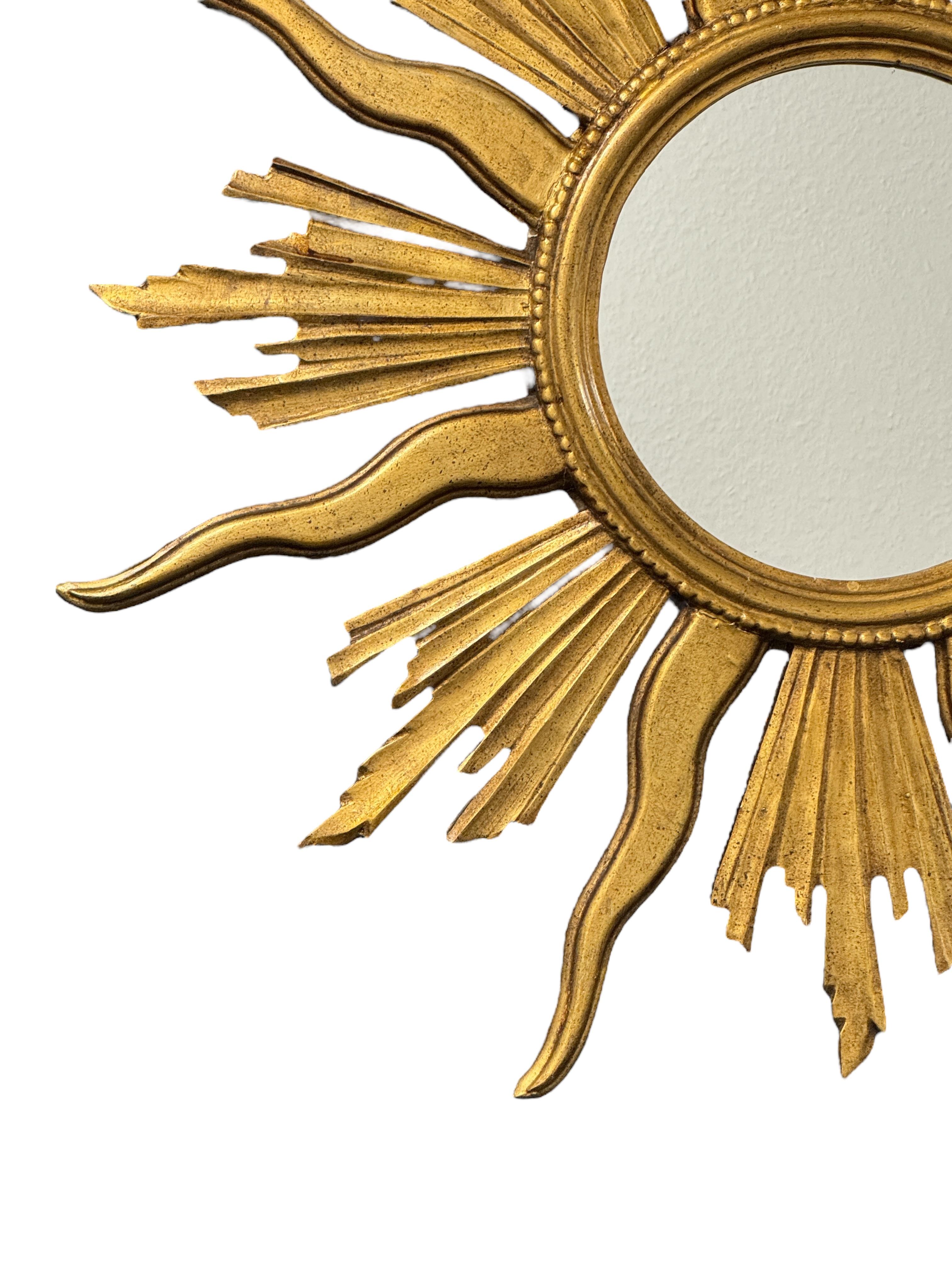 A gorgeous large starburst mirror. Made of gilded wood and original paper covered backside. No chips, no cracks, no repairs. It measures approximate: 32