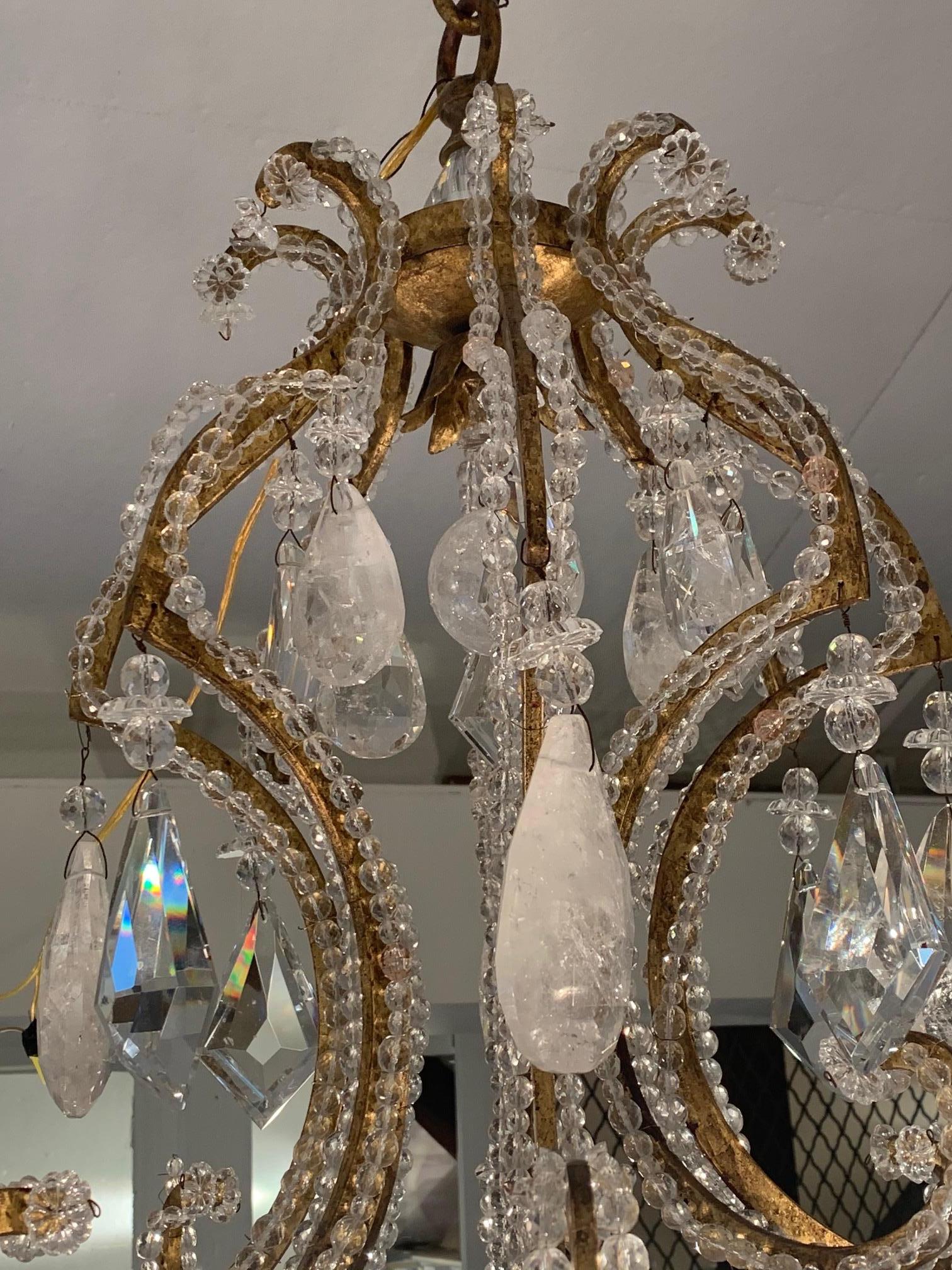 Impressively large and ornate brass and beaded crystal chandelier dripping with huge rock crystals.