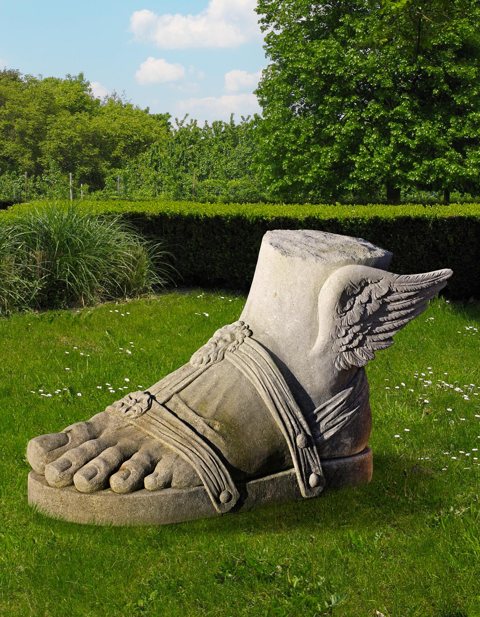 Large (XL) limestone sculpture of the left foot of Hermes, carved in Roman style.
This antique style garden statue features the iconic winged sandal of the god Hermes, with refined strap details. It is a unique and monumental garden ornament,