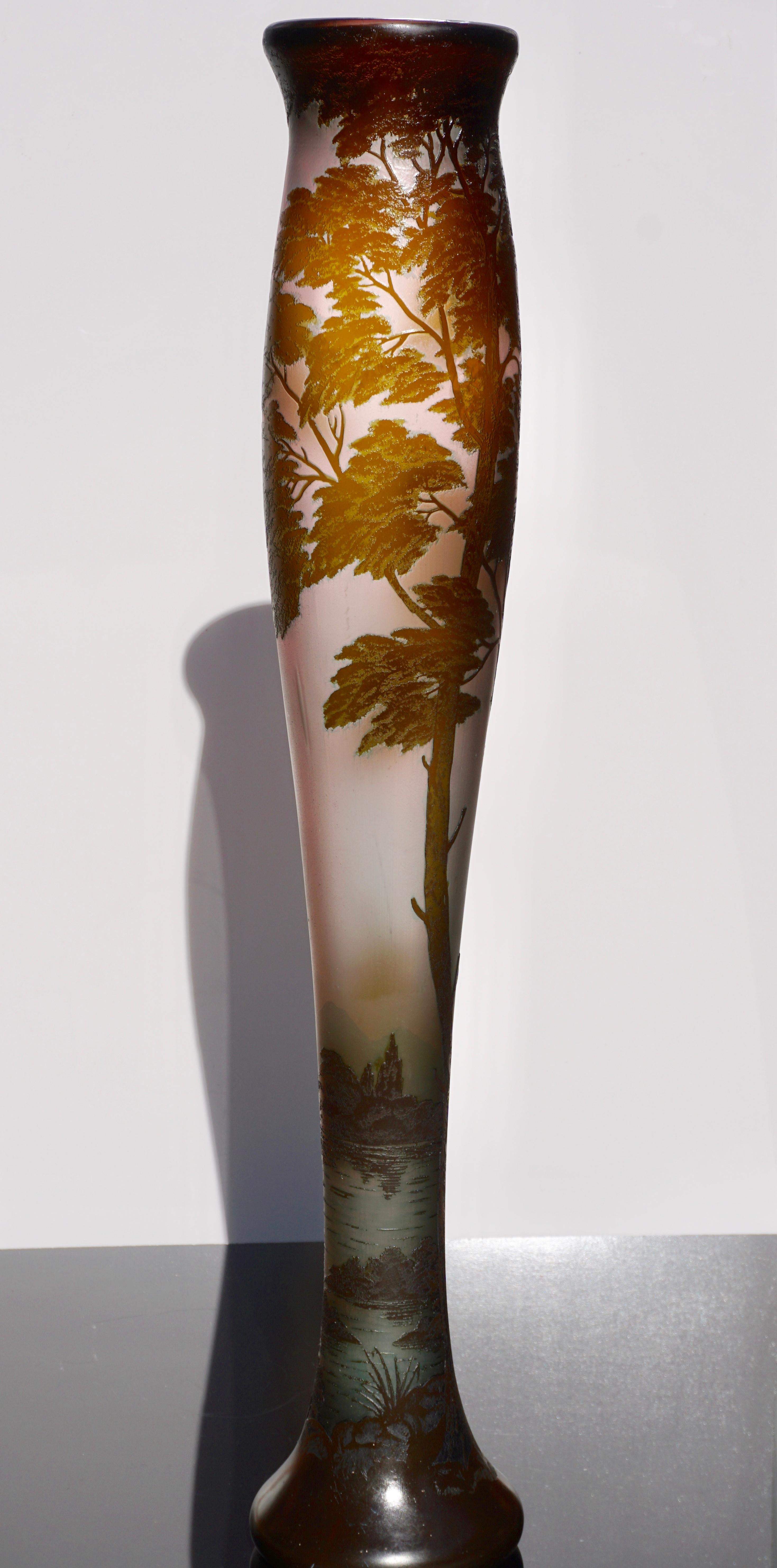 This stunning and monumental 32 Inch Loetz Richard vase is decorated with an olive green, pink, brown and blue cameo scene of a castle by a lake with tall trees towering over the castle. All set against a blue shading to pink sky. Multi color