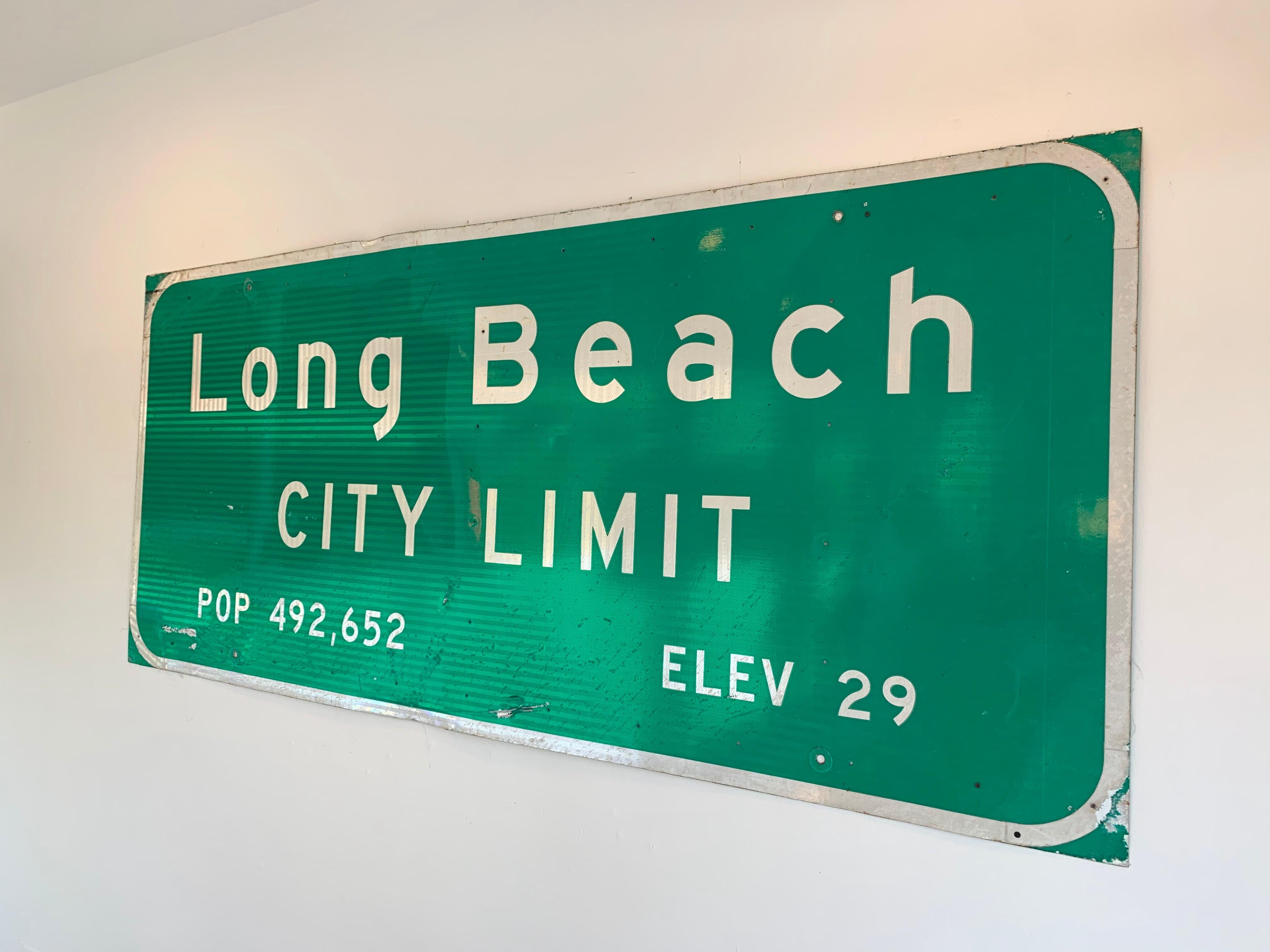 Super cool Long Beach freeway sign. 8 feet long and 3.5 feet tall. Metal freeway sign from California showing the Long Beach City Limit and population. Green reflective background with white lettering. Great piece of California history. Some wear to