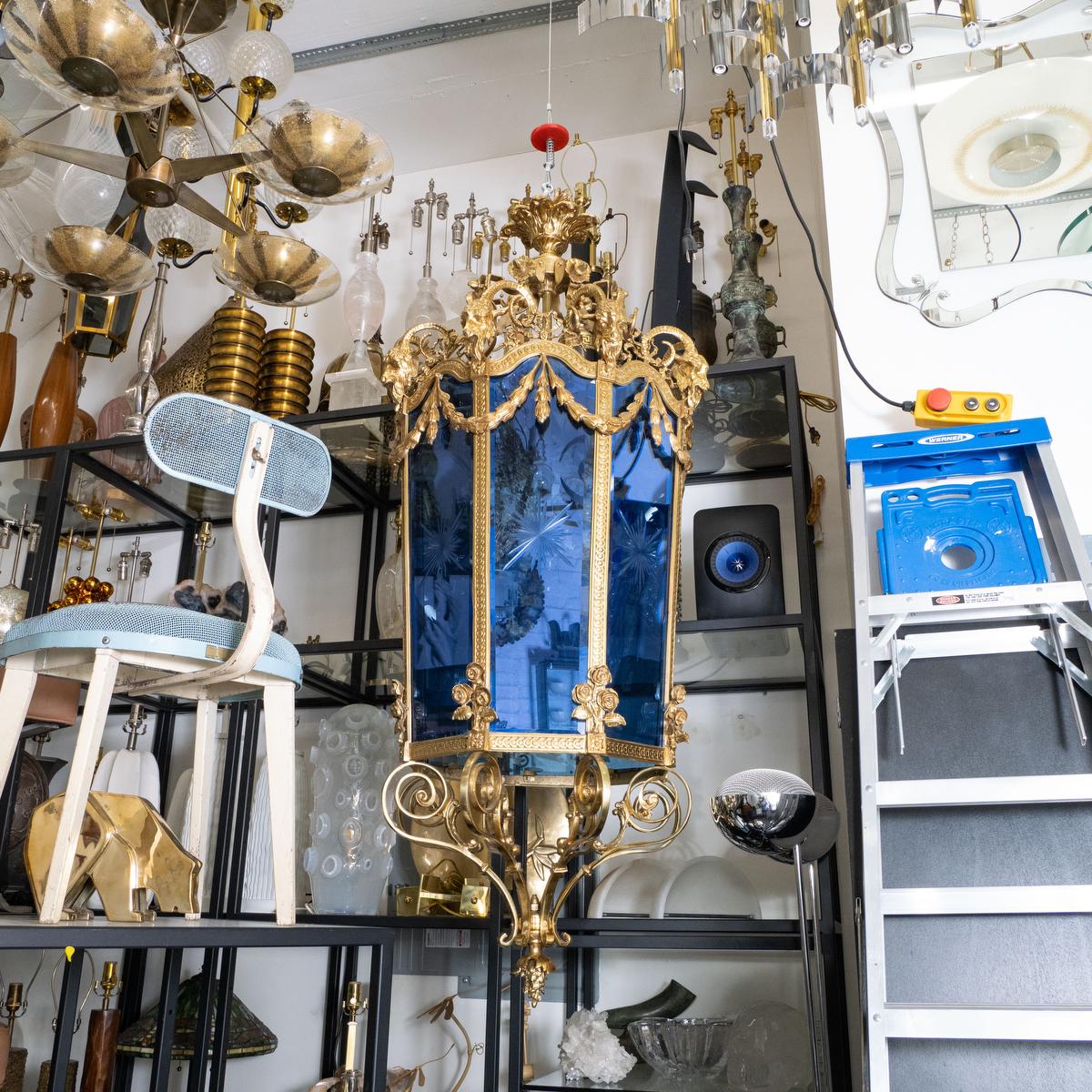 Lanterna monumentale in bronzo dorato in stile Luigi XVI con testa di ariete e motivi floreali e pannelli in vetro acidato blu.