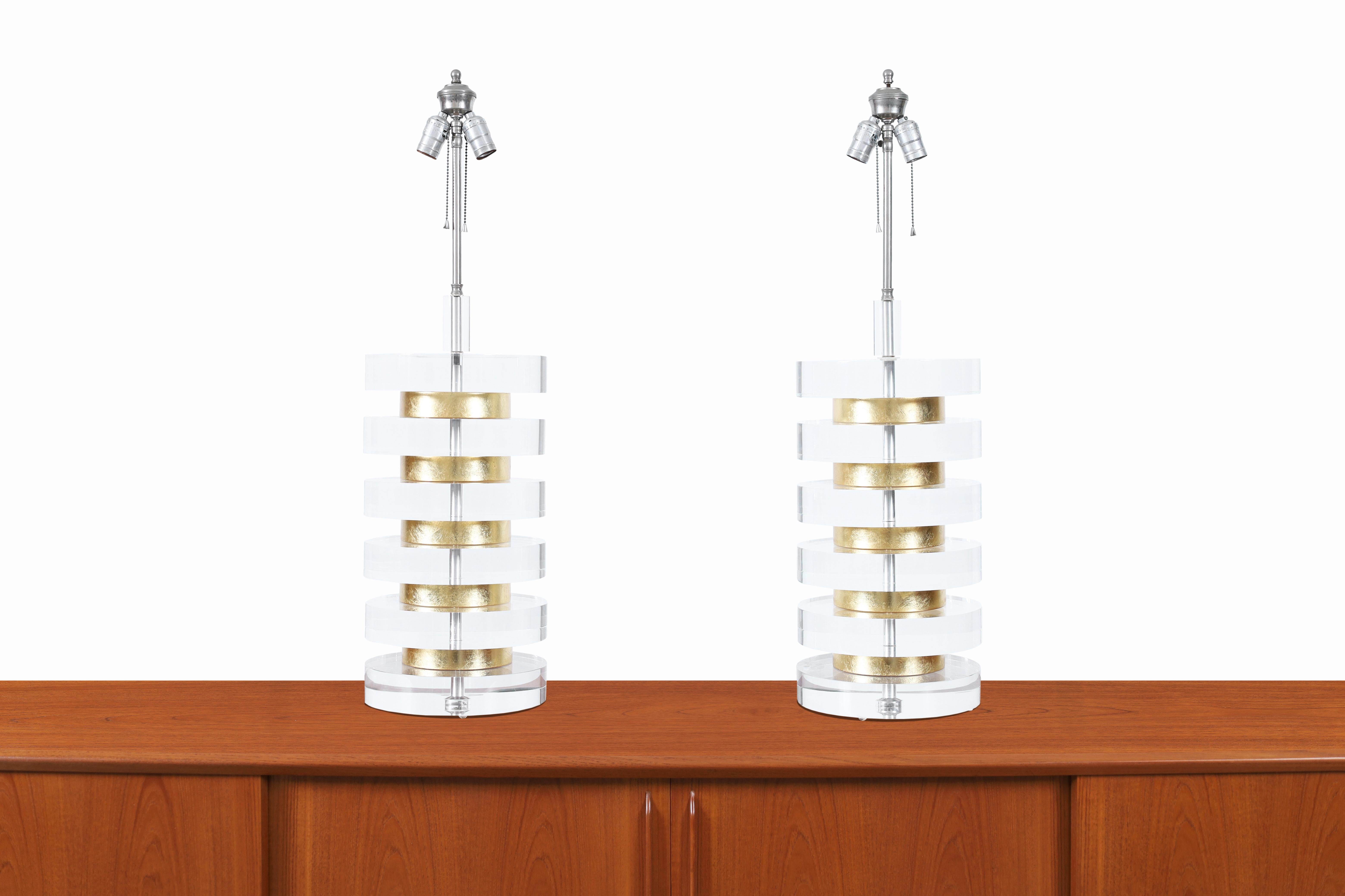 Wonderful monumental vintage lucite and gold leaf lamps designed and manufactured in the United States, circa 1970s. These lamps are inspired by the iconic designs of the famous designer Karl Springer. These lamps stand out for their modern design