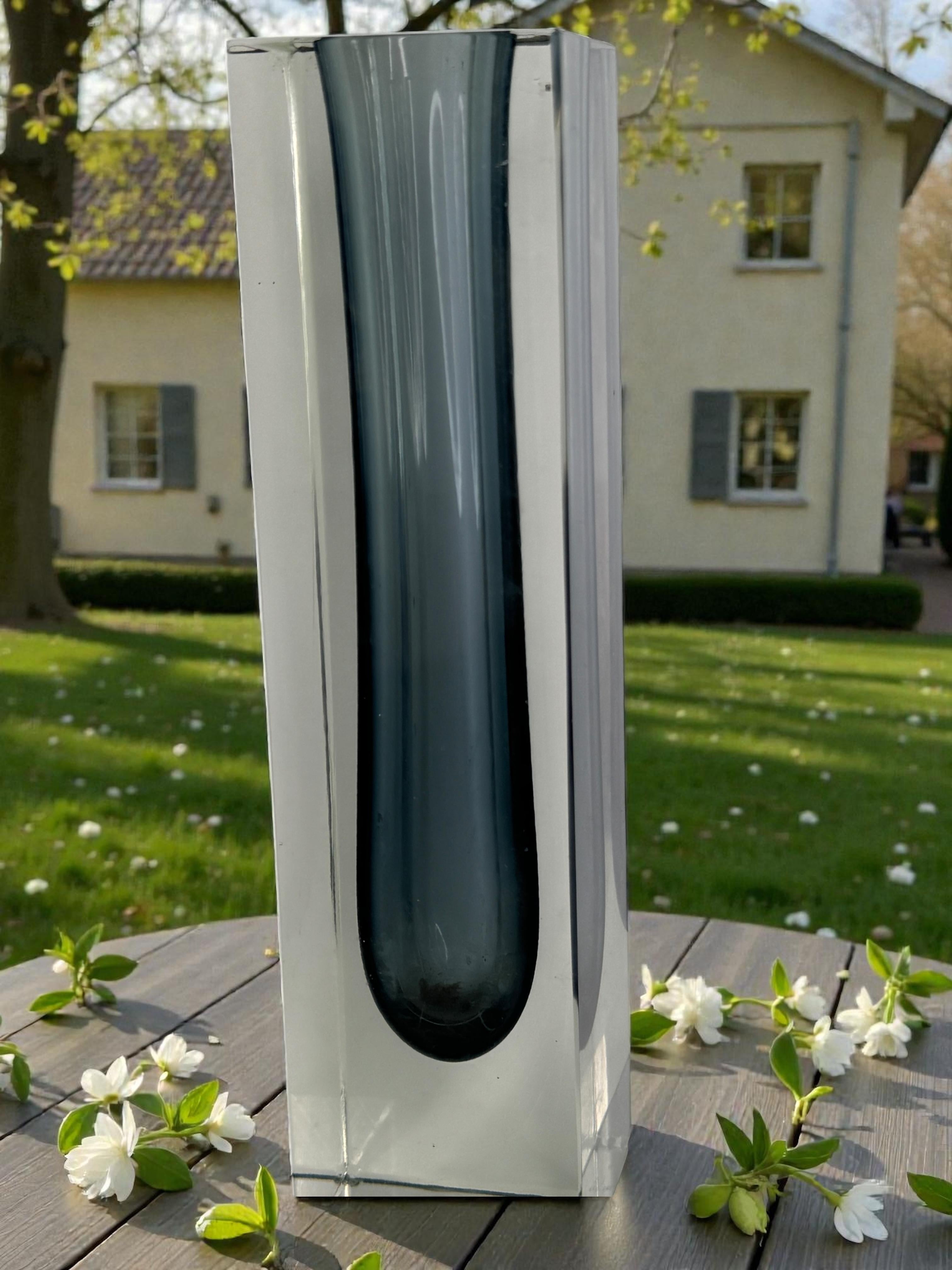 Excepcional jarrón veneciano de cristal de Murano de mediados de siglo, de estilo Mandruzzato, fabricado en Italia hacia la década de 1970. Este escultural jarrón en forma de bloque presenta un refinado núcleo gris encerrado en un grueso cristal