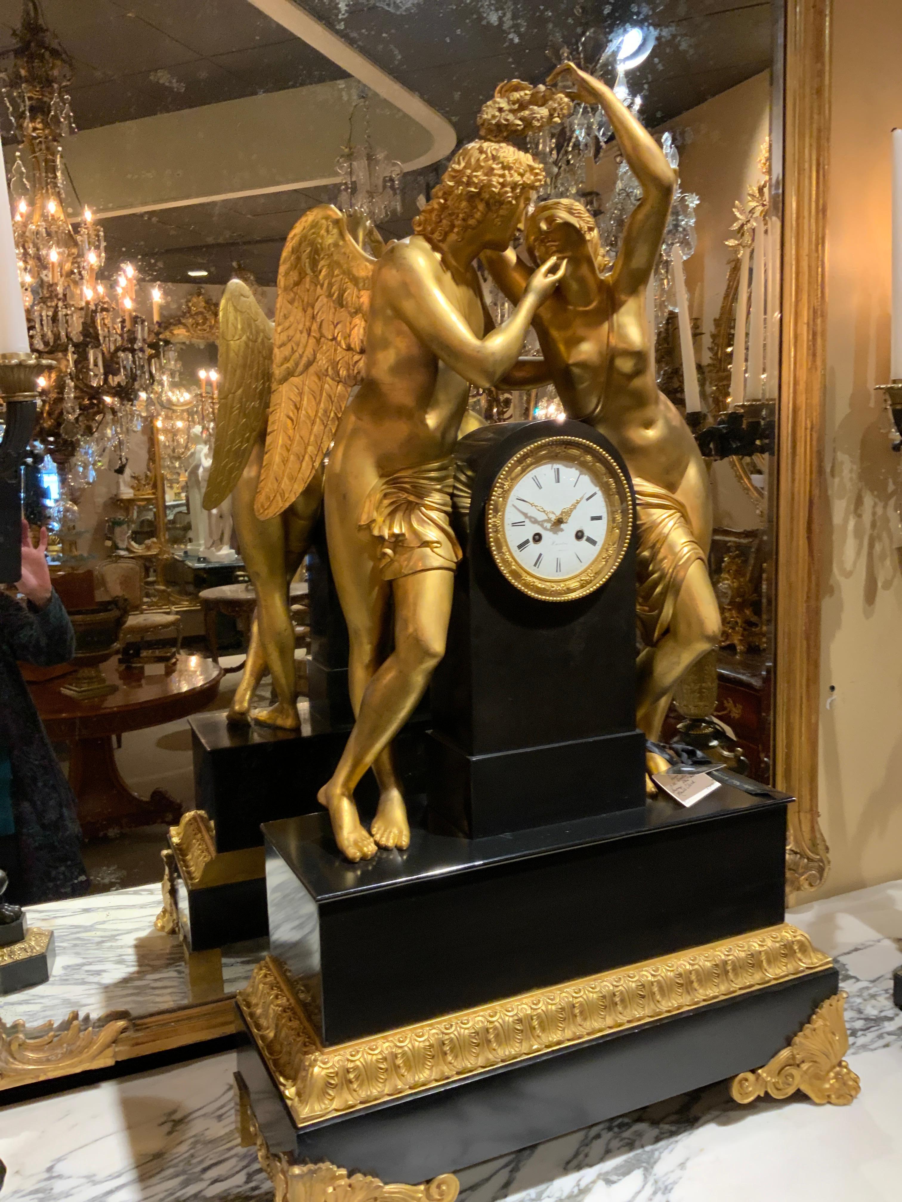 Amazing clock depicting the tale of Amor and Psyche which
Is about the god of love in Greek mythology. Large bronze
Dore figures adorn the pediment standing on a rectangular
Marble base. It has an enamel face marked with Roman numerals. On the face