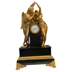 Reloj monumental de mármol y bronce adornado con las figuras de Psique y Amor