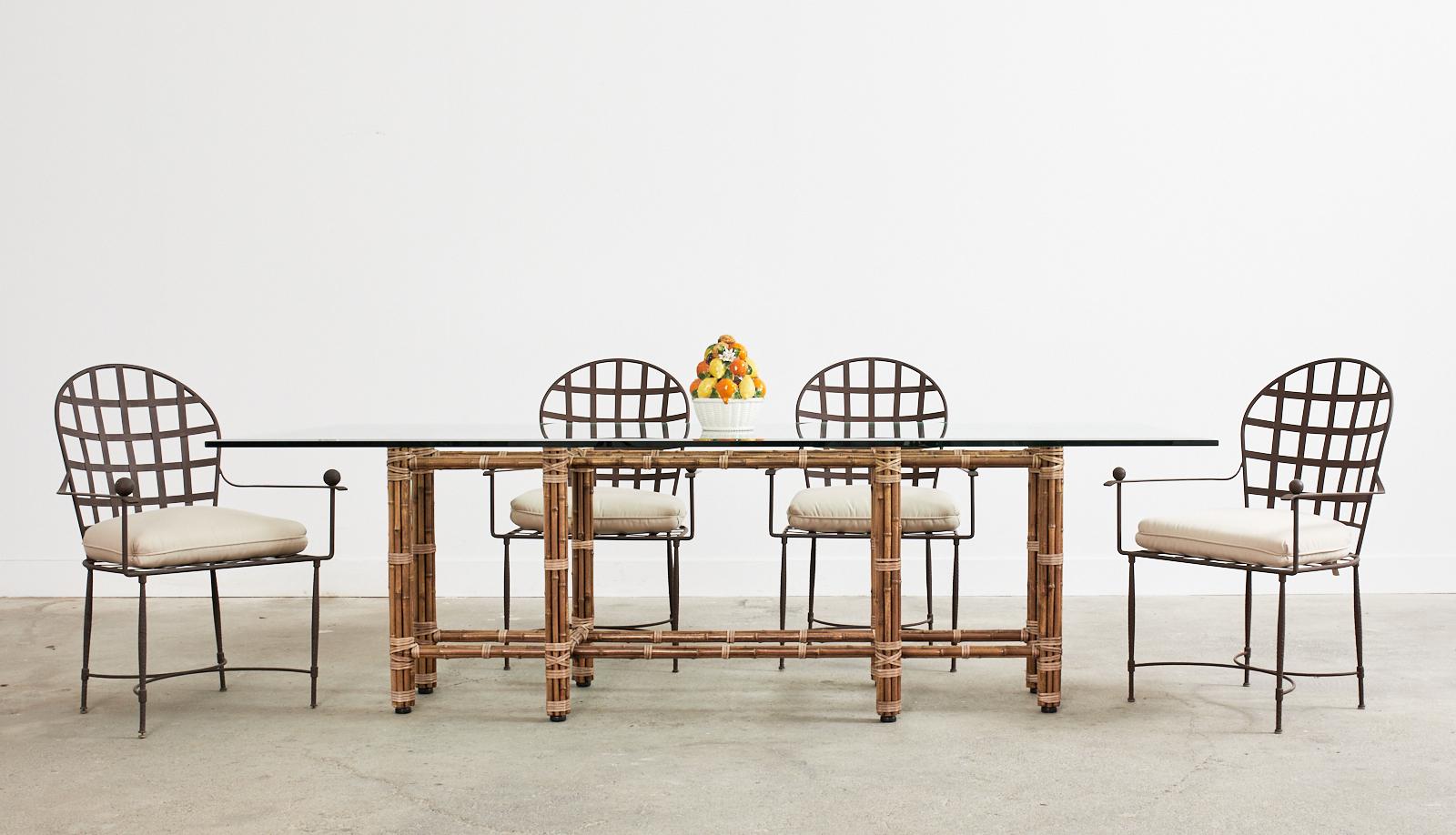 Bespoke monumental McGuire rectangular dining table made in the organic modern style. Authentic, genuine McGuire table with an iron frame painted golden gate orange for authenticity. The frame is wrapped with tobacco toned bamboo poles lashed