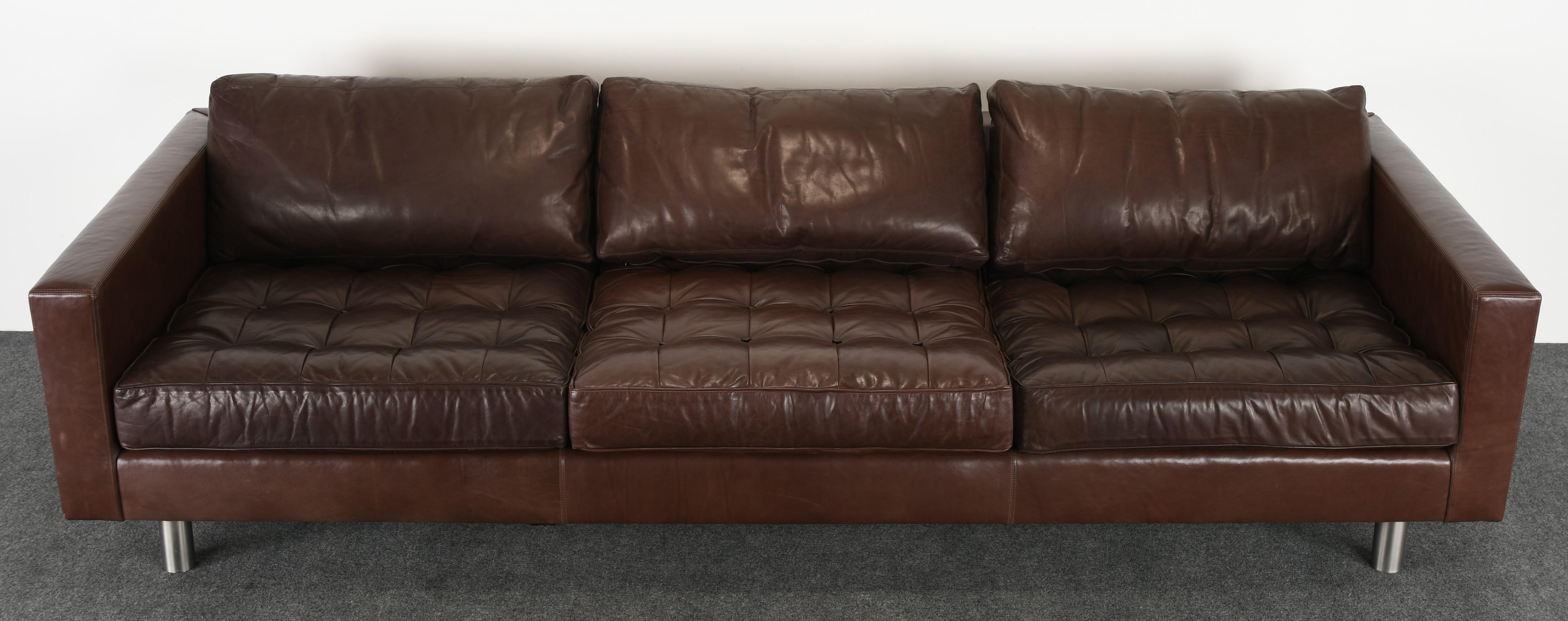 A fabulous large-scale sofa by Ralph Lauren upholstered cocoa or chocolate brown leather with tufted button cushions. This sofa has a brushed aluminum finish on steel legs. The cushions may have been reupholstered in faux leather at some point.