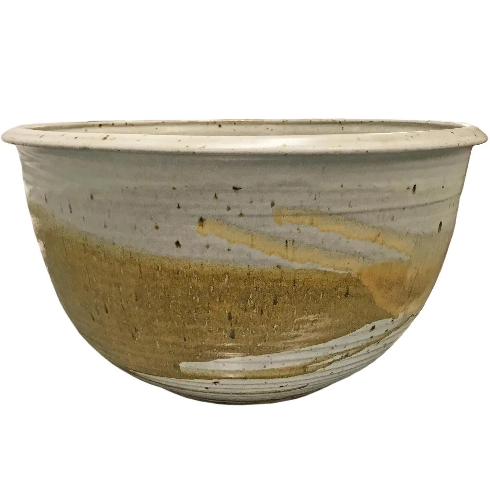 A monumental-scale mid-20th century American studio hand-thrown glazed ceramic bowl with fantastic texture and earthy neutral glaze colors. Signed illegibly on the bottom.