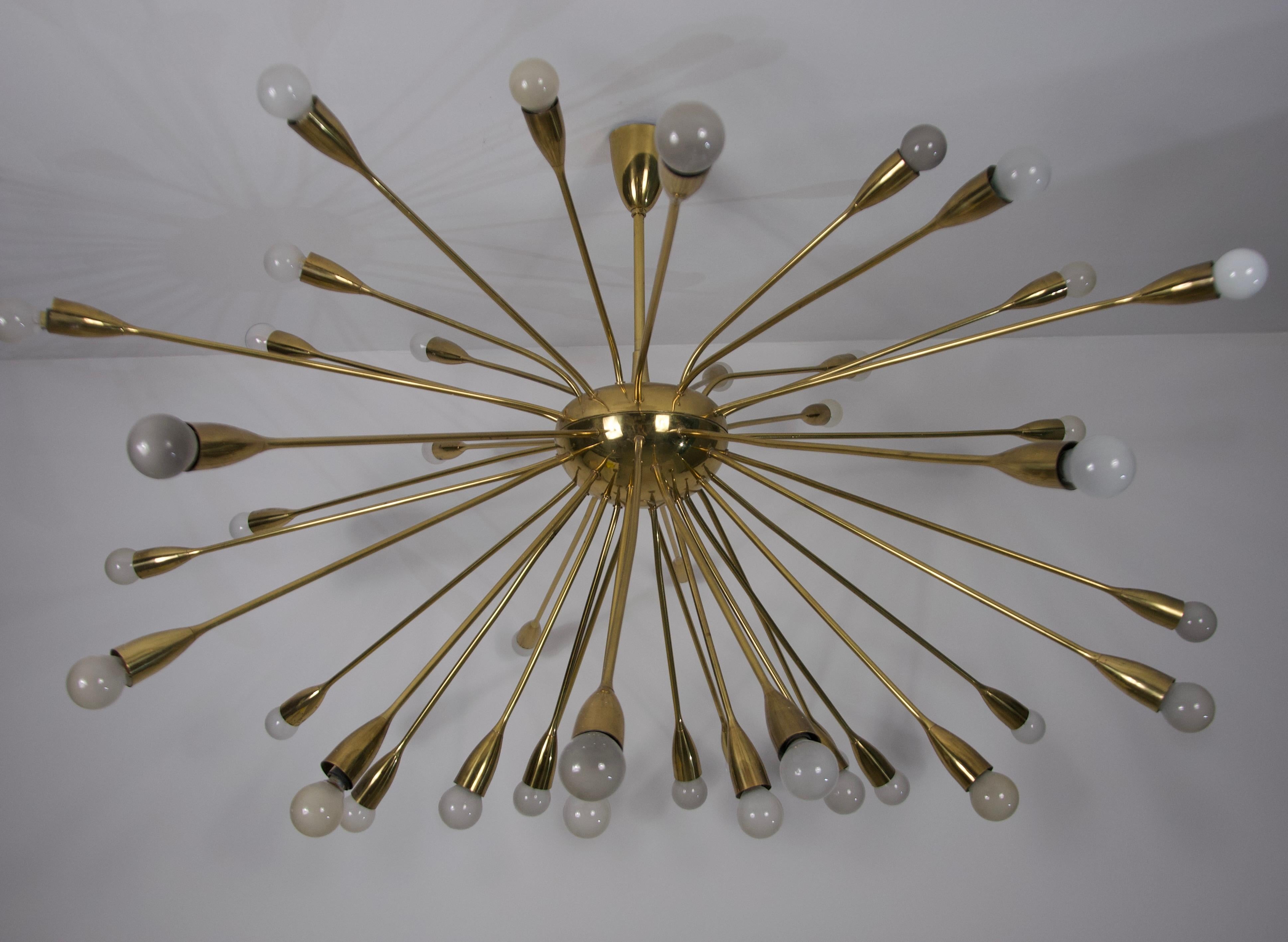 Questo lampadario in ottone dalle dimensioni mozzafiato, proveniente dalla Germania degli anni '50, è un vero e proprio pezzo forte. Recentemente smontato da una villa di Monaco, questo straordinario apparecchio è probabilmente una creazione