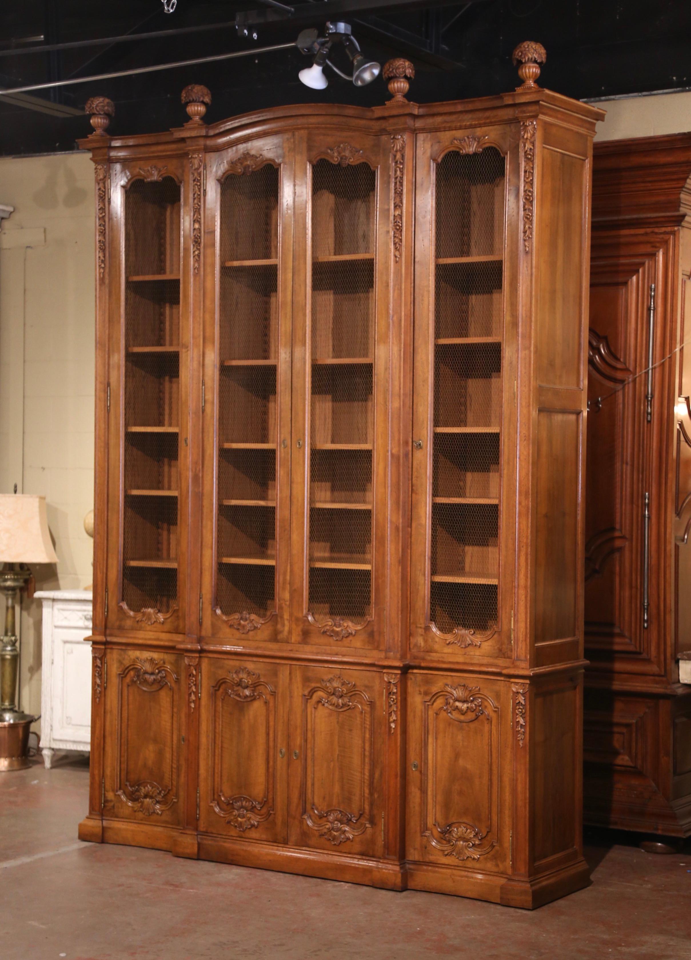 Decorate a study, an office or a library with this spectacular 10.5 feet bookcase! Created in France circa 1970, the important cabinet stands on a wide bottom plinth over four doors including double center doors and serpentine side doors, opening to