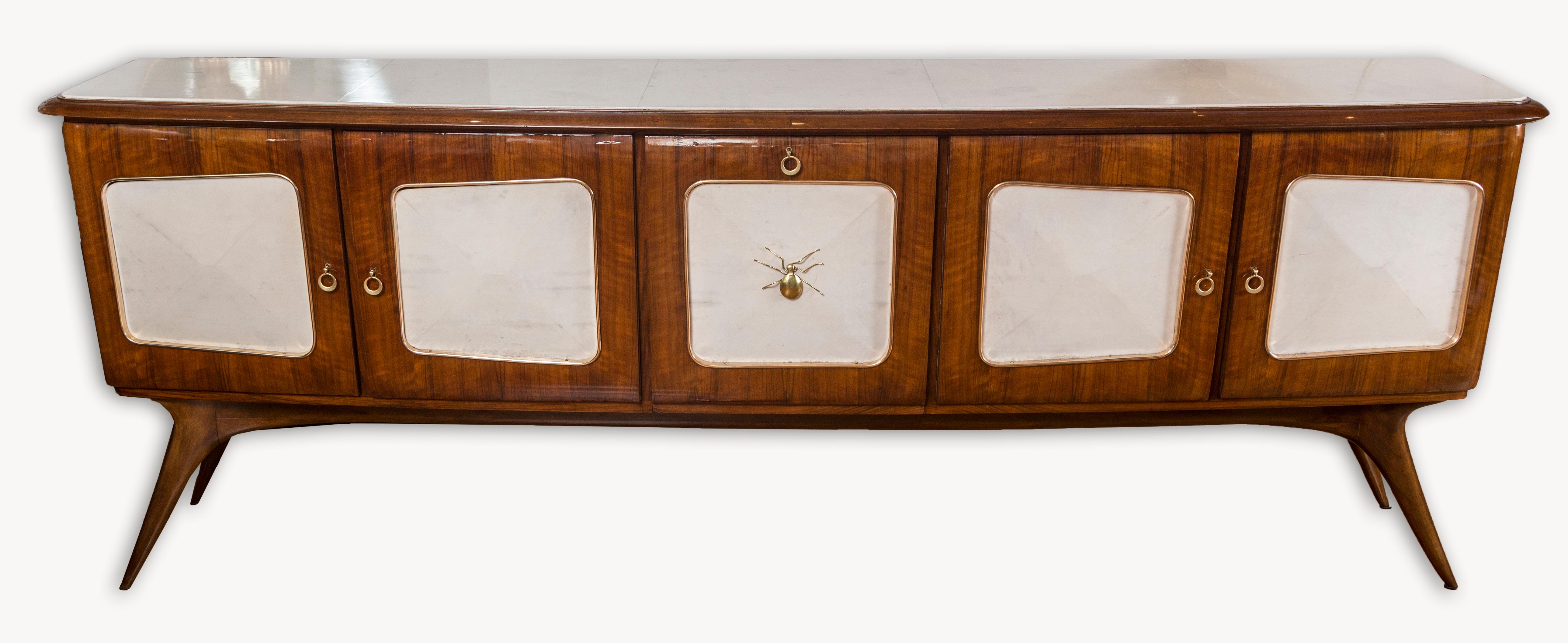 Finely crafted mid century Italian credenza cabinet in palisander and comprised of a slightly bowed rectangular-shaped bevelled plateau in parchment above five asymetrical shaped doors with brass mouldings and parchment center panels finishing on