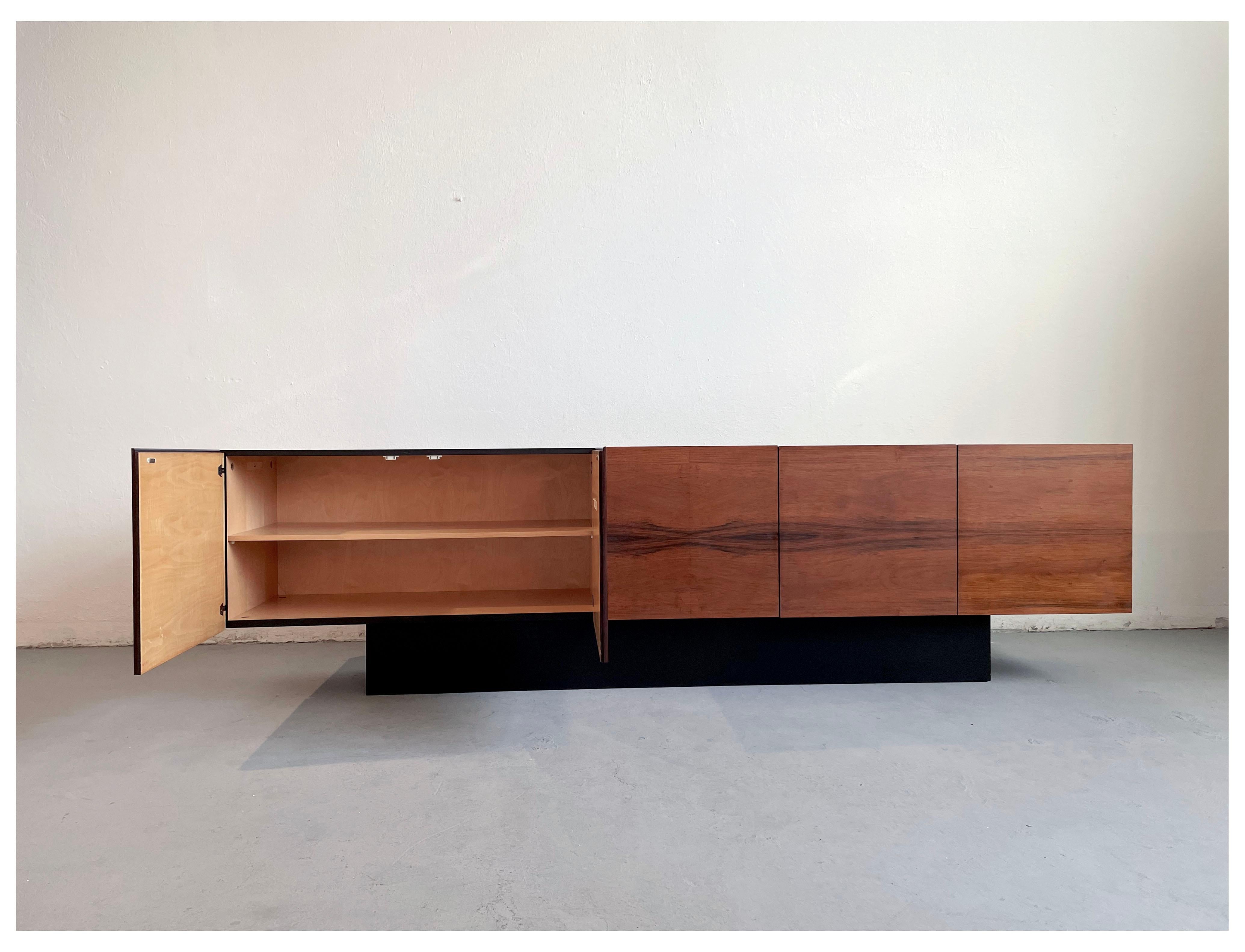 Very large vintage sideboard from the 1970s, minimalist design, and monumental proportions

The sideboard is made of wood veneered in black Formica and Rio rosewood

Visually most impressive are the five minimalist front doors made of Rio