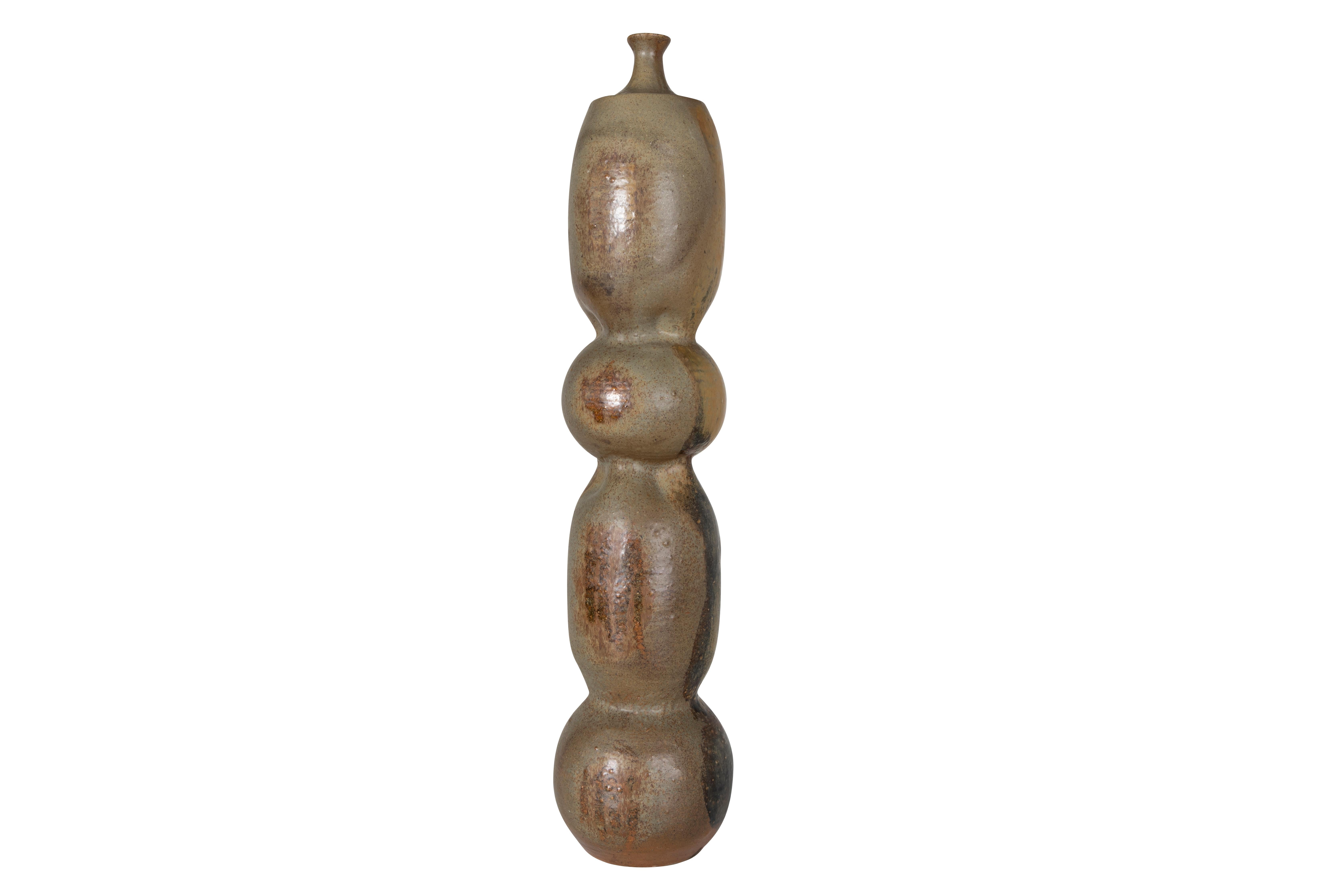 This Mid-Century Modern pottery vase circa 1976 was hand-crafted in a small independent studio by an unknown artist. Organic form body measuring 33 inches tall. Piece is in very good condition with gorgeous coloring.

The piece is a part of our