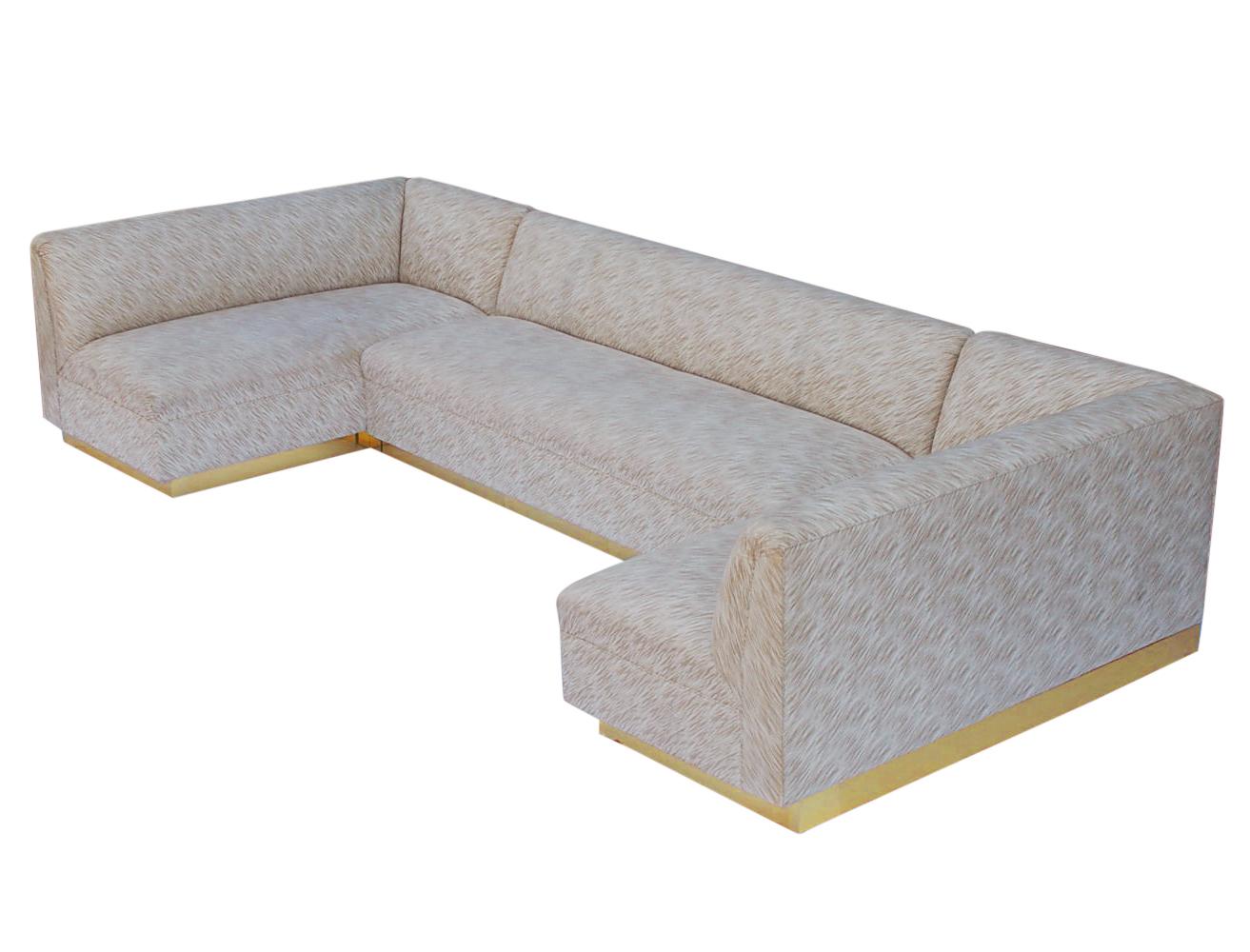 A large custom made sofa, circa 1970s. It features a three piece U-shape design with a full brass plinth base. Upholstery is original and in good clean usable condition.