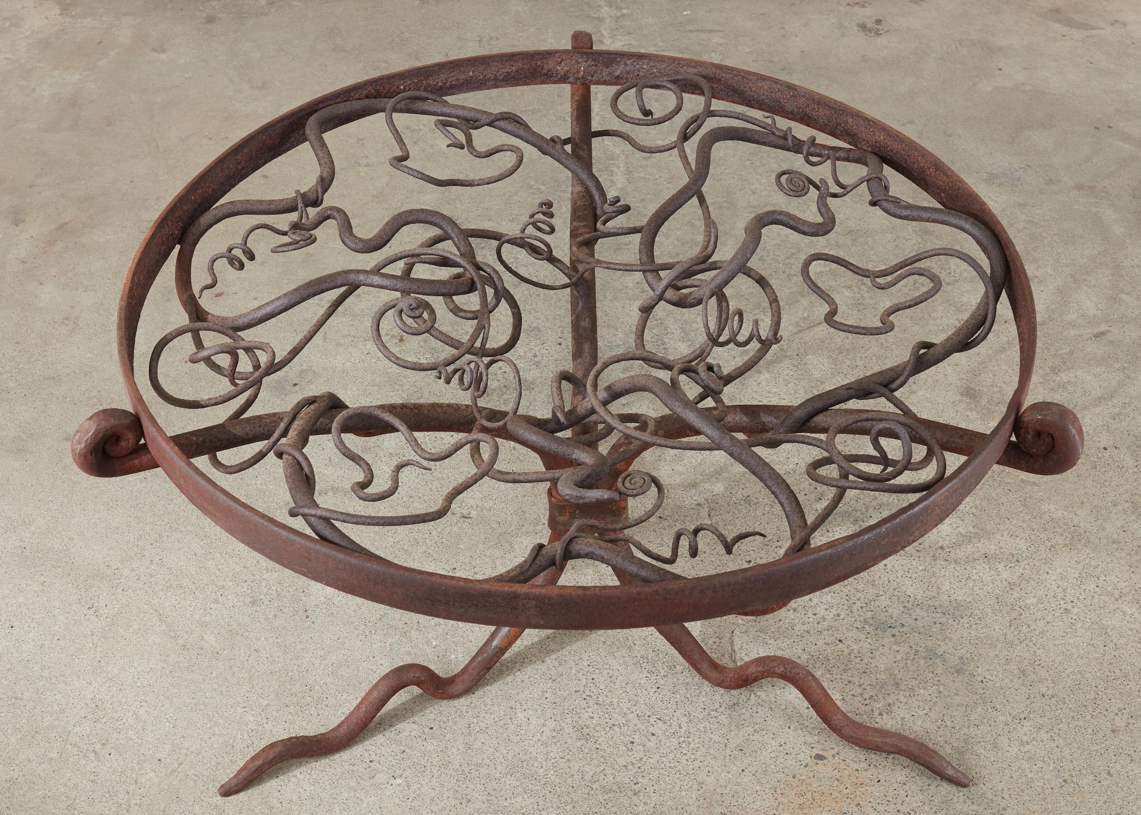 Mid-Century Modern iron center table or garden patio table made on a monumental scale. The Brutalist style sculpture is supported by three branch style legs ending with scrolled fronds on top. The legs are conjoined in the middle and on the top with
