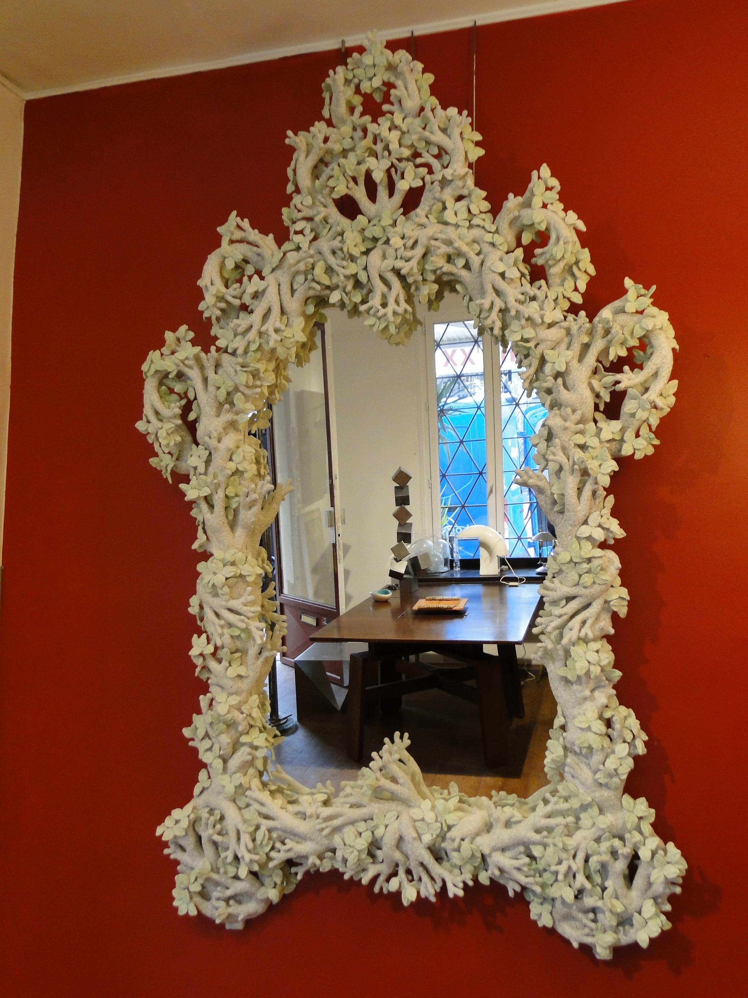 Grand and ethereal, this large scale plaster framed mirroris a showstopper.
The plaster is made up of white and green branches and leaves created in papier-mâché by the French artist Edouard Chevalier.
