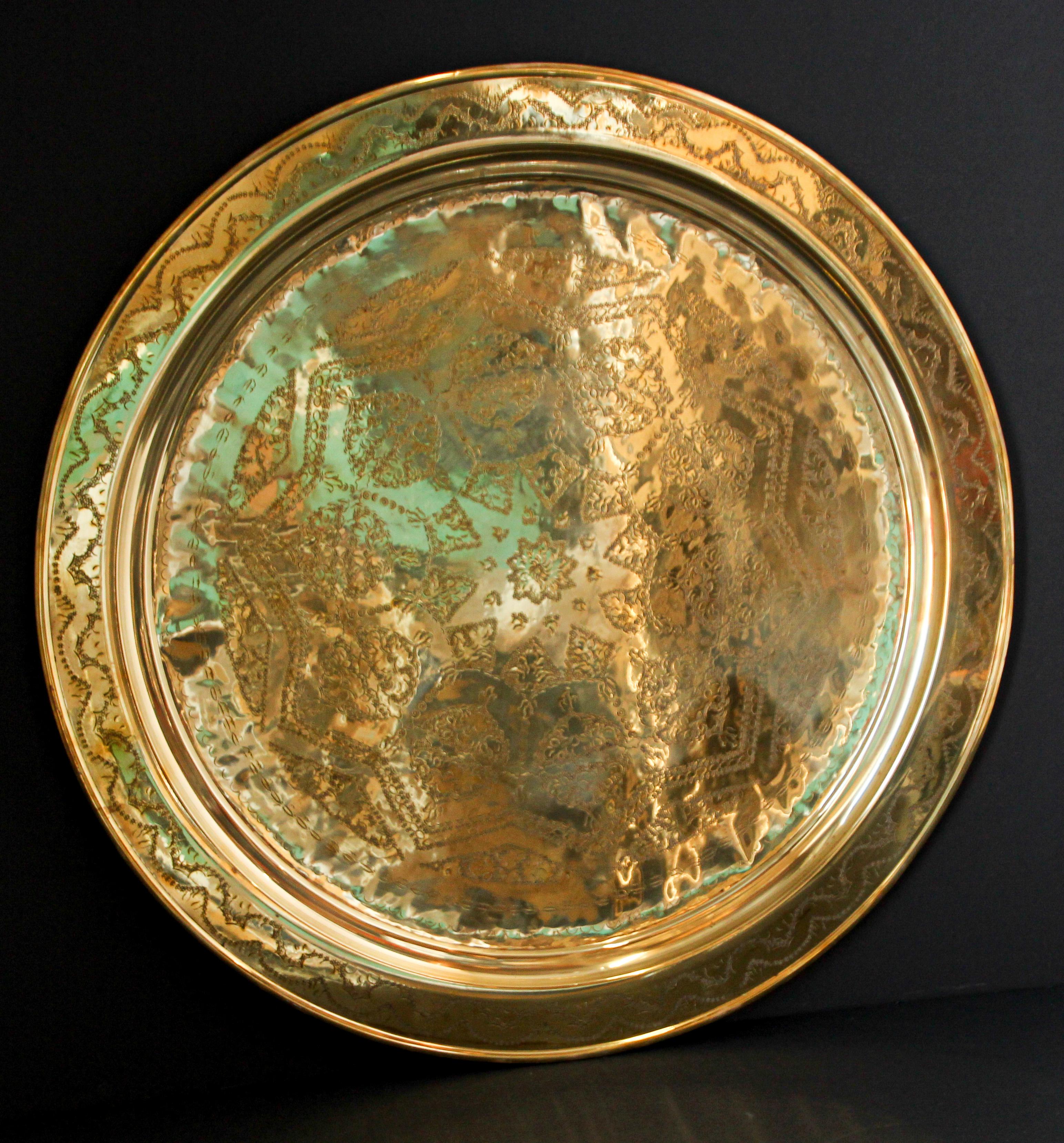 Monumental Moroccan metal polished brass tray platter.
Polished decorative metal brass tray with very fine intricate Moorish geometric designs.
Hand-hammered and chiseled in geometric Moorish style with a large star in the middle.
Heavy brass metal