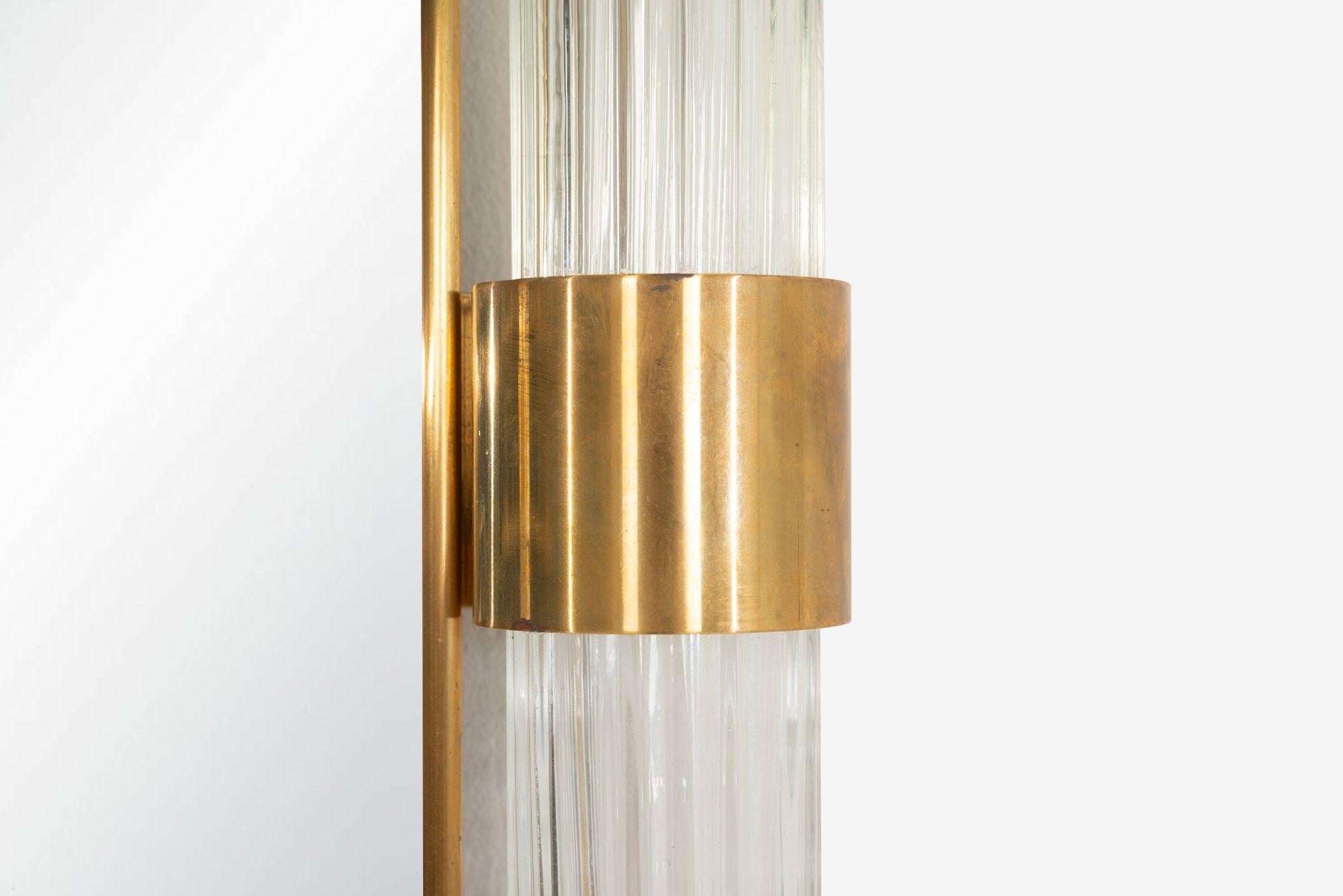 Espejo monumental de cristal de Murano con detalles de latón macizo, Italia, 1965
Sorprendente ejemplo de la artesanía italiana de mediados de siglo, este espejo monumental presenta un marco estriado de cristal de Murano acentuado con soportes de