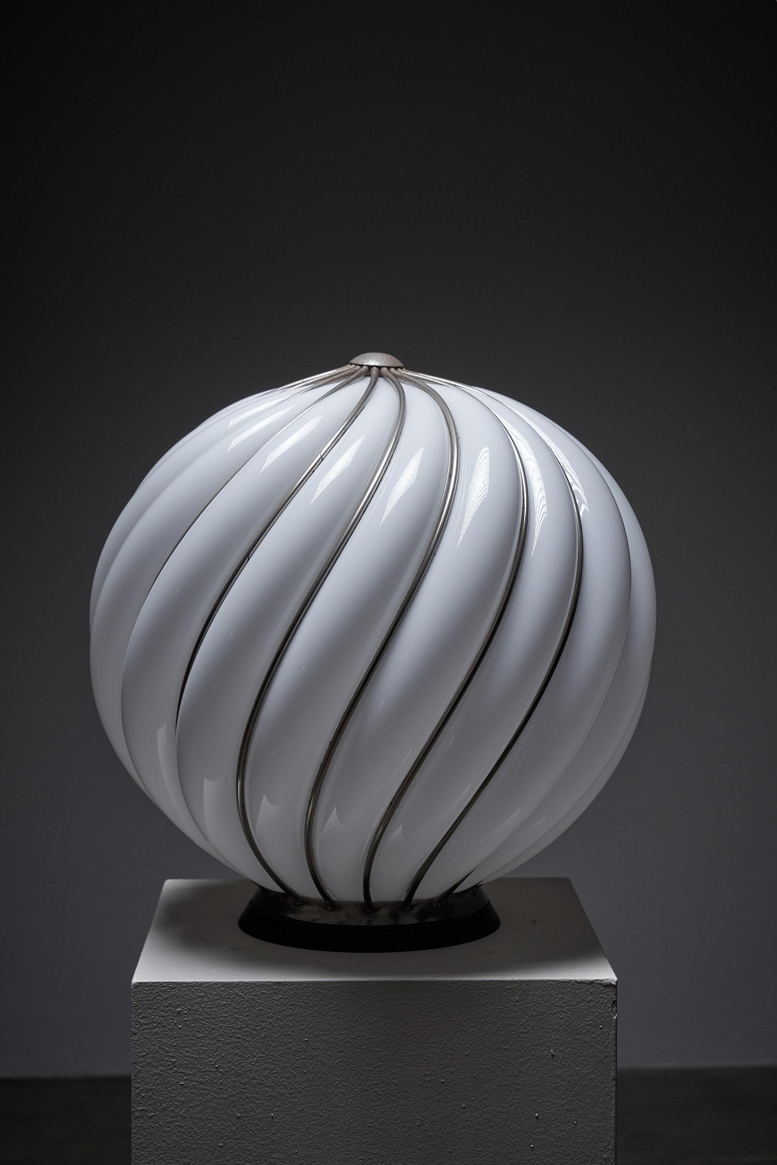 Gran Lámpara de Esfera de Vidrio Soplado VeArt de 50 cm, Jaula de Alambre, Space Age Italia

Lámpara de sobremesa monumental, diseñada por el arquitecto austriaco Adolf Loos y fabricada por el vidriero italiano VeArt en los años 70, que tiende un