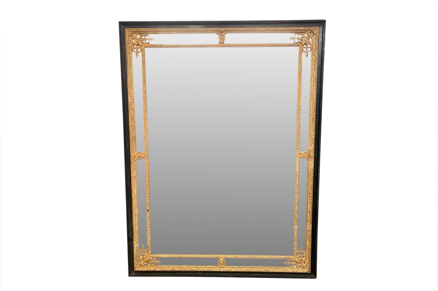An outstanding and monumental Napoleon III period Mirror. Wonderfully constructed from ebonized wood with gold gilt decorative trim. The mirror retains its original glass. A very elegant mirror will be the statement of its surroundings.