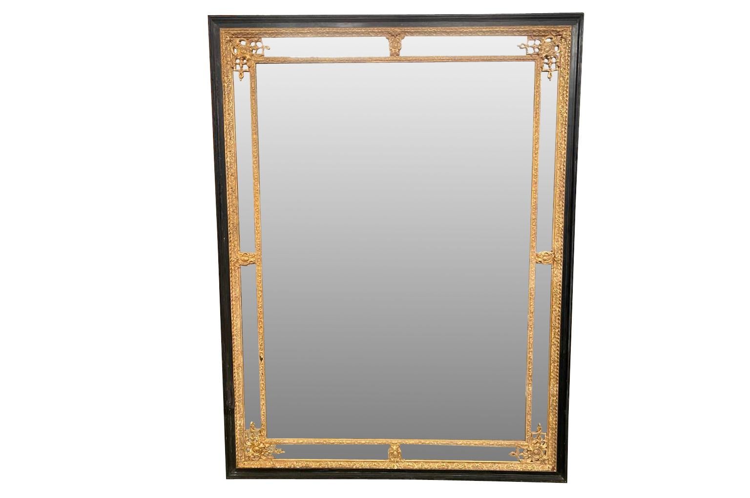 An outstanding and monumental Napoleon III period Mirror. Wonderfully constructed from ebonized wood with gold gilt decorative trim. The mirror retains its original glass. The glass has been photoshopped in the photos.  A very elegant mirror will be