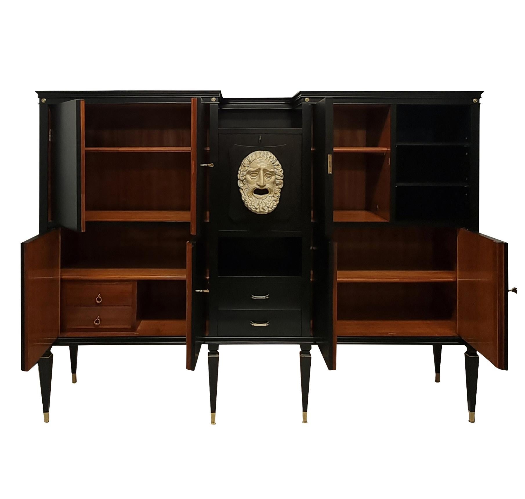 An Italian bar cabinet of monumental proportions by Paolo Buffa. In the neo-classical taste, it comprises four large cupboards, shelves and two drawers, each lined in sapele wood. The central bar cabinet is mirror lined with a fall front door and