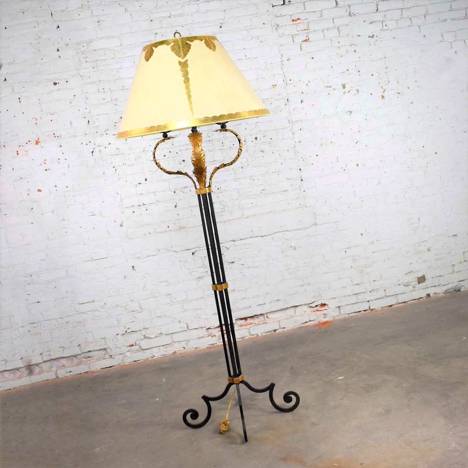 Beautiful monumental sized neoclassical style iron floor lamp with a gilt acanthus leaf design and an enormous parchment shade with gold leaf design. This piece is not marked but we feel is in the style of Marge Carson. It is in fabulous vintage