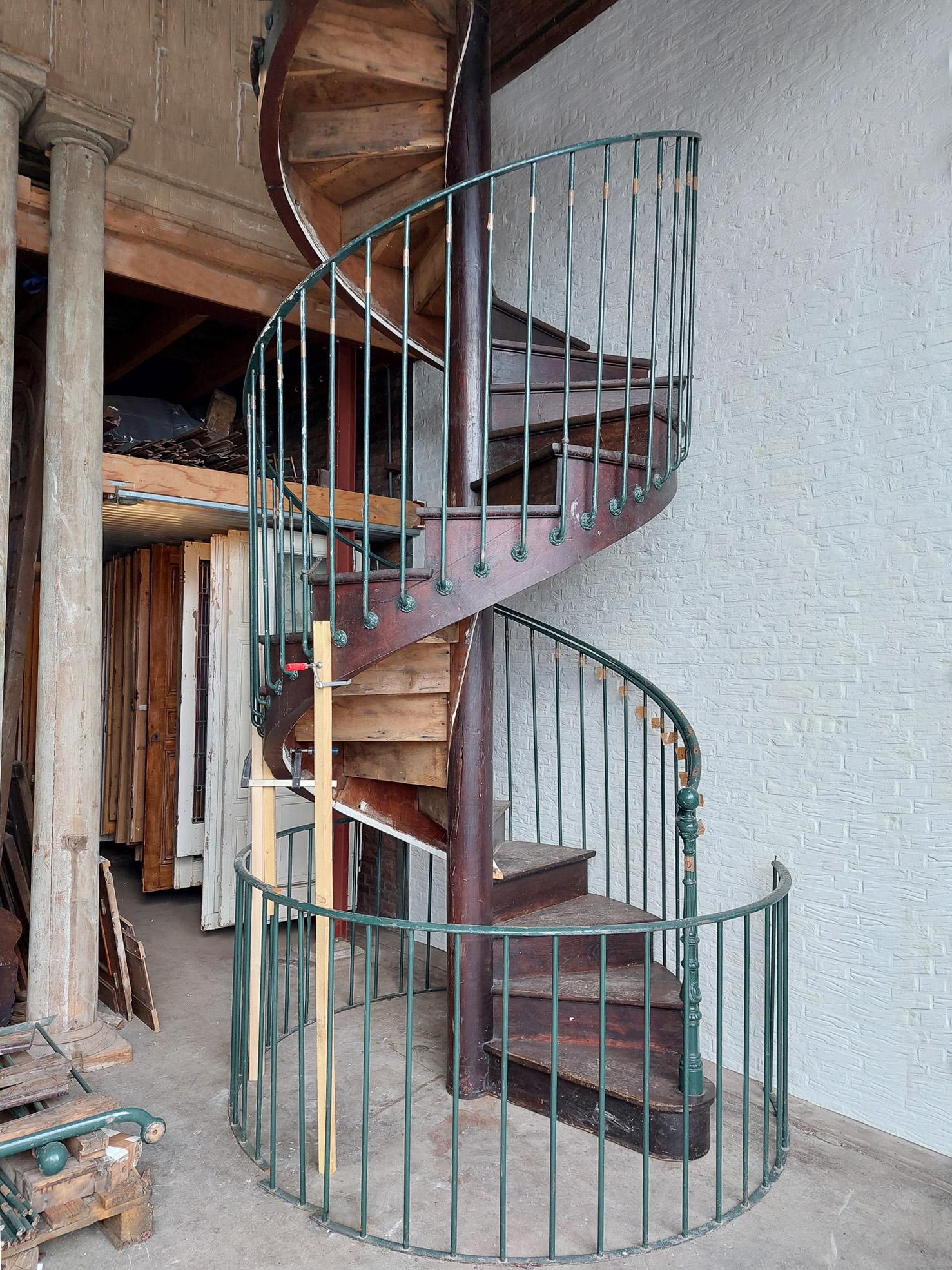 A monumental, completely free-standing, dark oak spiral staircase. The central newel of this very large spiral staircase consists of an entire solid oak tree trunk, which is made into a strong pole with a diameter of 30 cm. Because of this, the