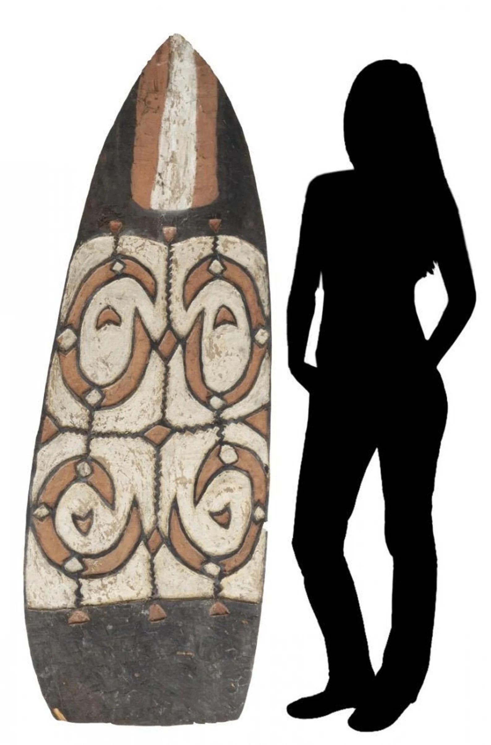 A monumental, rare and important Oceanic Papuan Asmat People tribal carved war shield from the first half of the 20th century, collected from the coast of the headhunting tribe in Papua New Guinea, a Provincial Indonesian island in the mid 20th