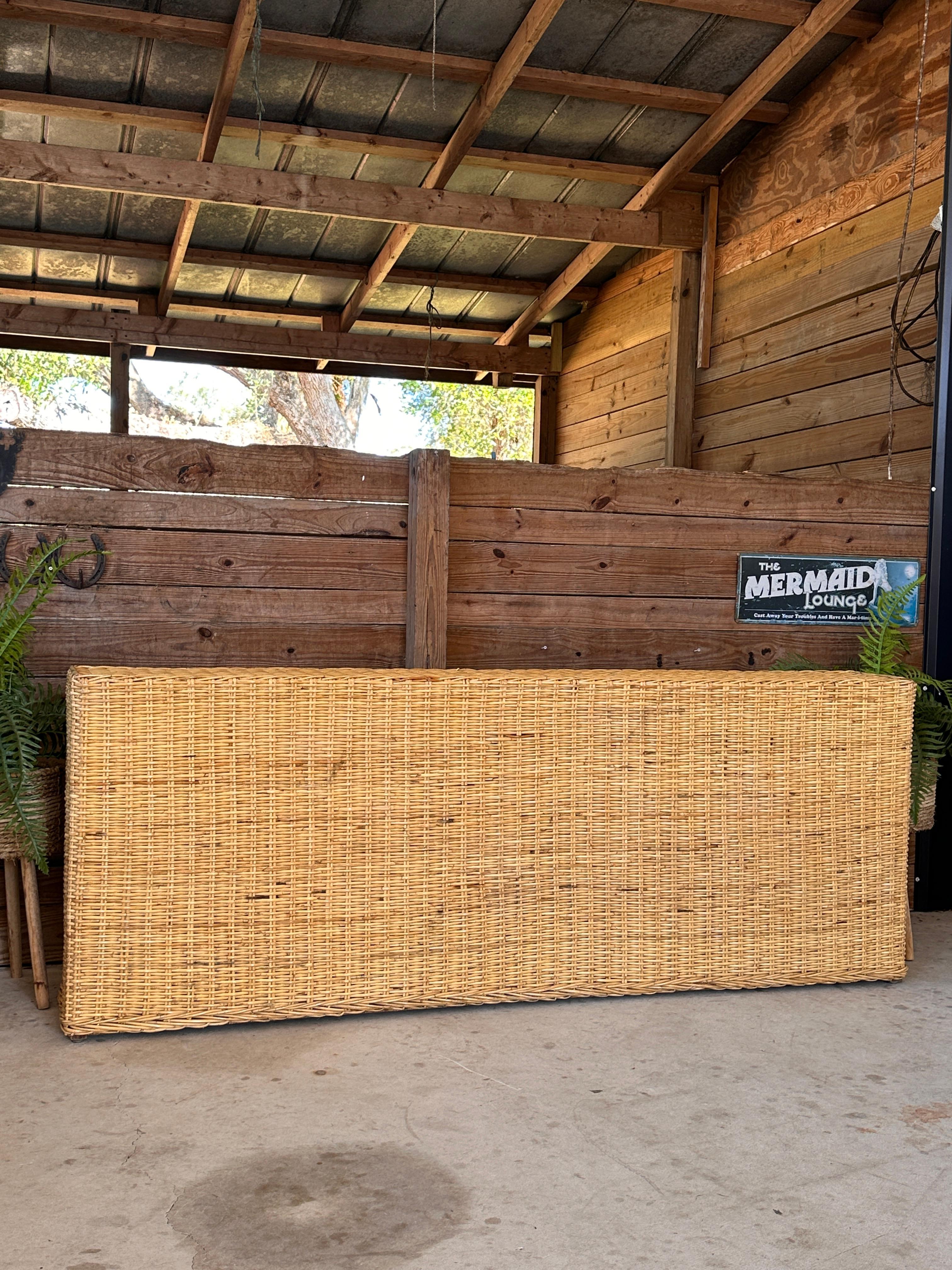 Esta llamativa consola de tejido de ratán de los años 80 encarna el diseño moderno orgánico con sus líneas limpias y su tamaño considerable, de Wicker Works.
Su armazón de ratán natural firmemente entretejido aporta textura y durabilidad, mientras