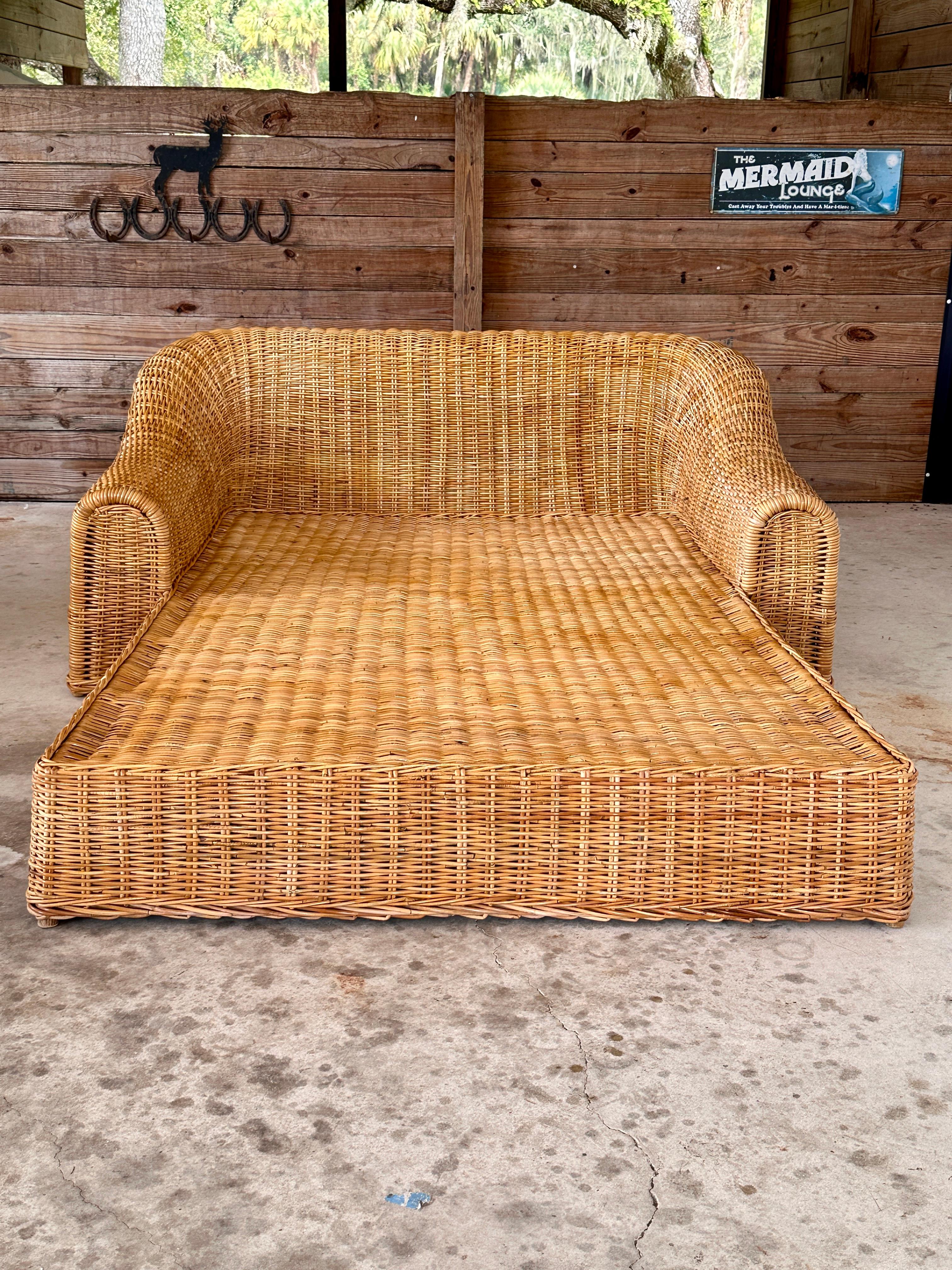 This impressive Late 20th Century Organic Modern Coastal Rattan Chaise Lounger by Michael Taylor for Wicker Works is a statement piece designed for relaxation and style.
Its monumental form is handwoven from natural rattan, creating a soft, flowing