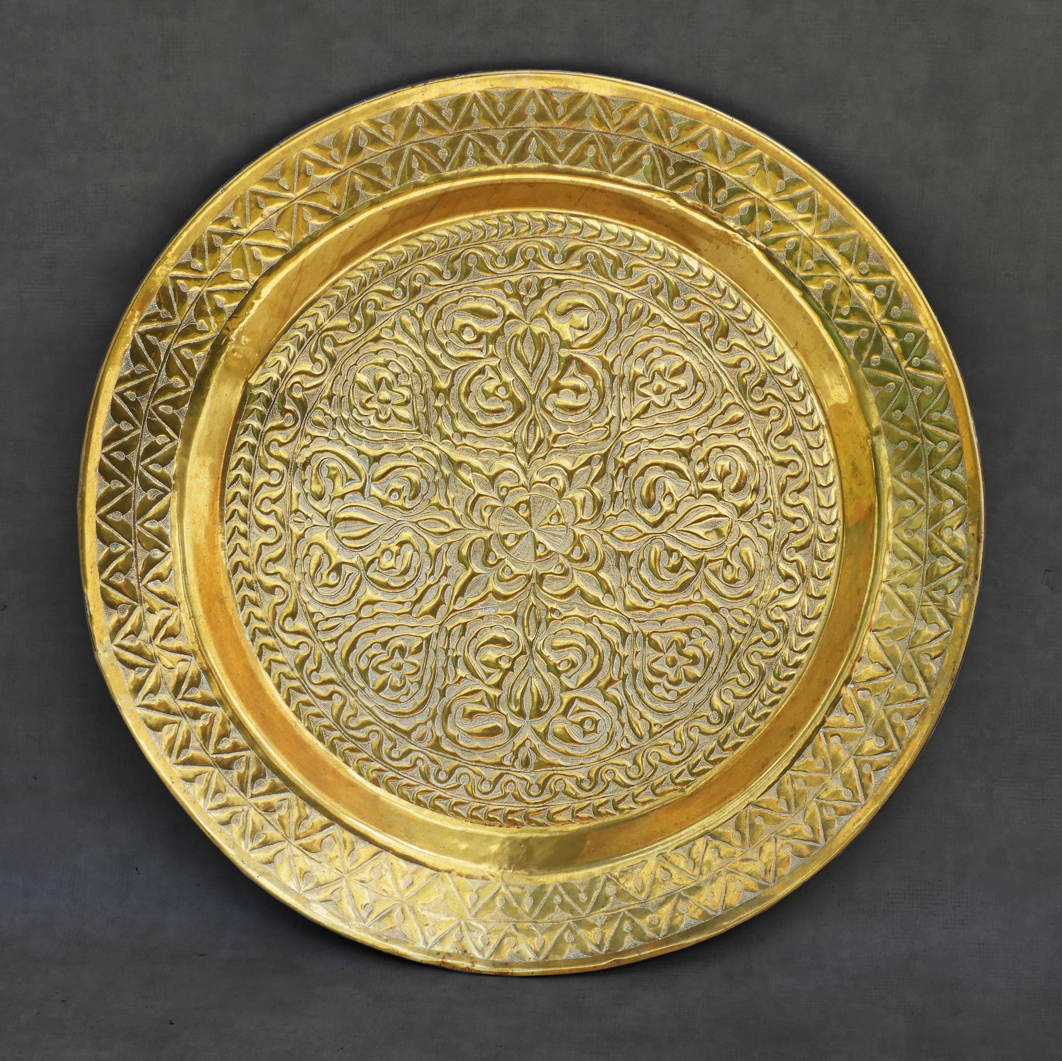 Monumental oriental brass charger, c1960.

Unusual oversized decorative wall plate, beautifully handcrafted in brass and gorgeously embossed in a free-flowing symmetrical design. 

In good vintage condition with nice patina, some minor denting – not