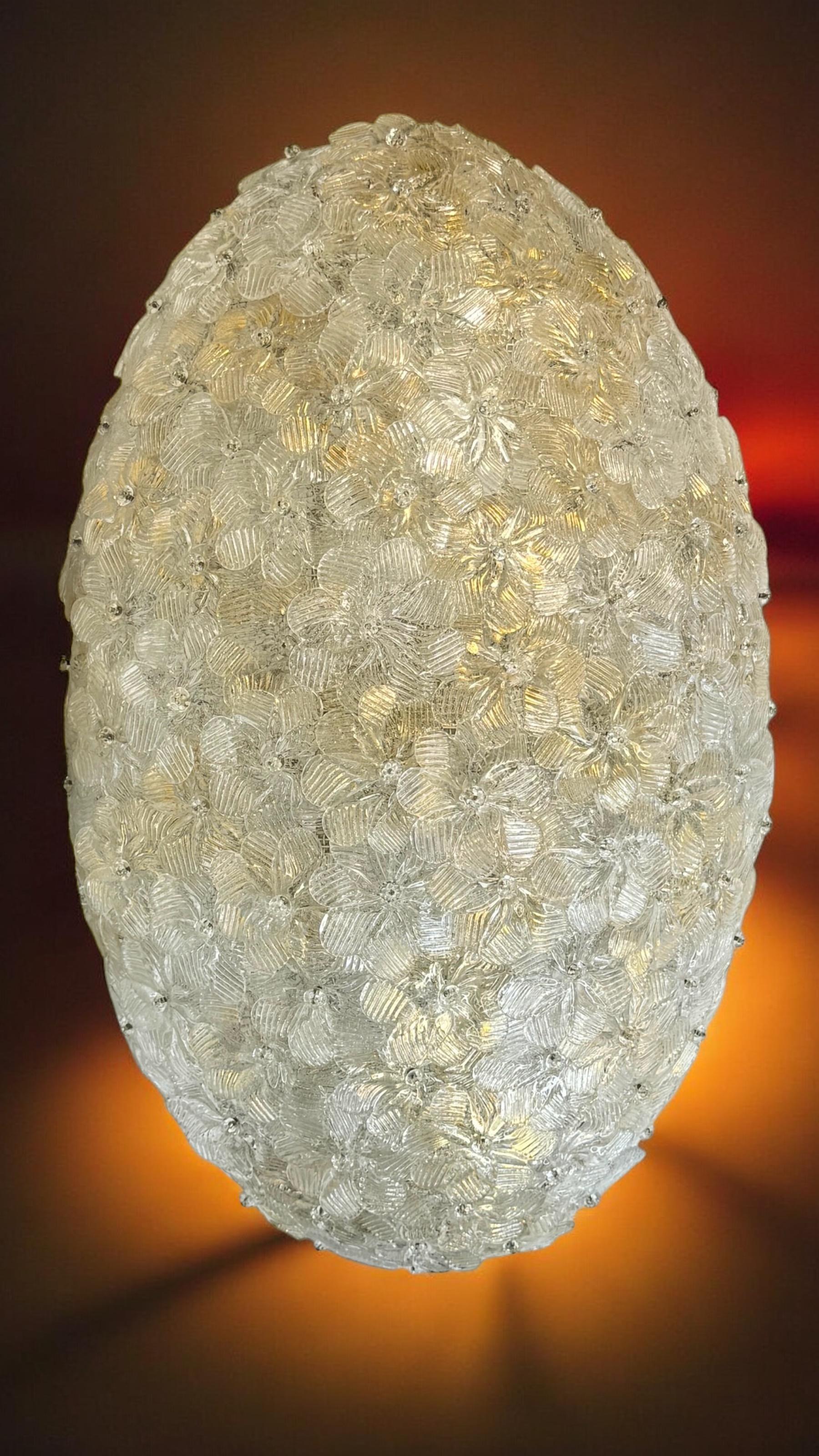 A hand blown Italian flush mount chandelier featuring overlapping crystal flowers, gold with 23-carat gold leaf fleck inclusions, mounted on a basket frame. The fixture requires eight European E14 / 110 volt candelabra bulbs, each bulb up to 60
