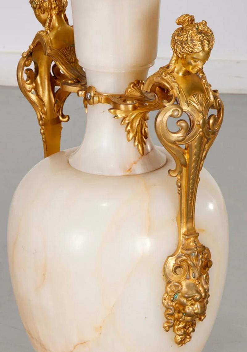Paire monumentale de candélabres anciens français Napoléon III en bronze et onyx blanc, datant de la fin du XIXe siècle. En forme de balustre avec des poignées en bronze doré en forme de bustes de cariatides féminines et terminées par des masques de