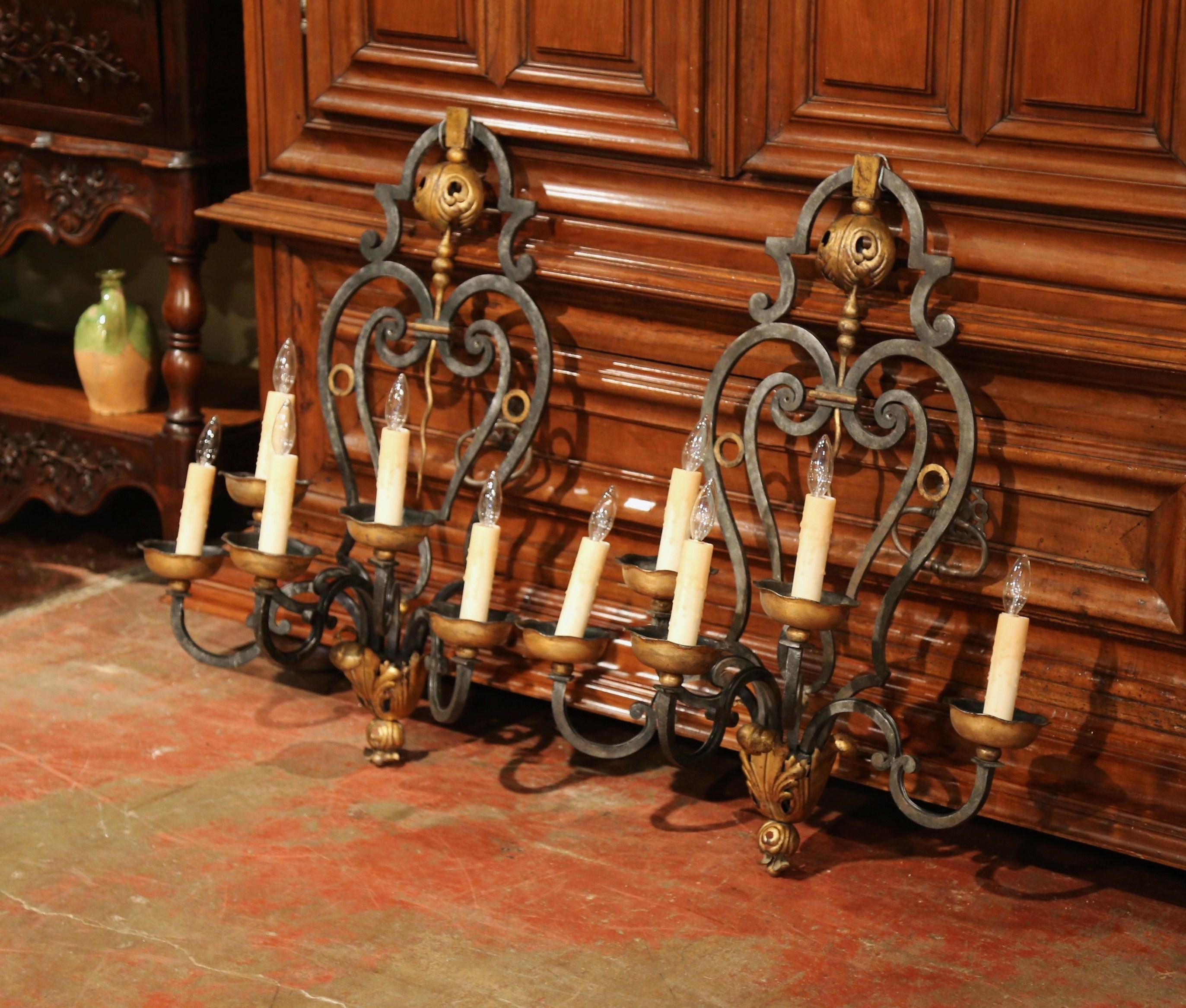 Place these important iron sconces on both side of your mantel for a grand, rustic look. Crafted in France, circa 1870, the large antique wall fixtures features five newly wired lights embellished with decorative wax candle sleeve covers. Each