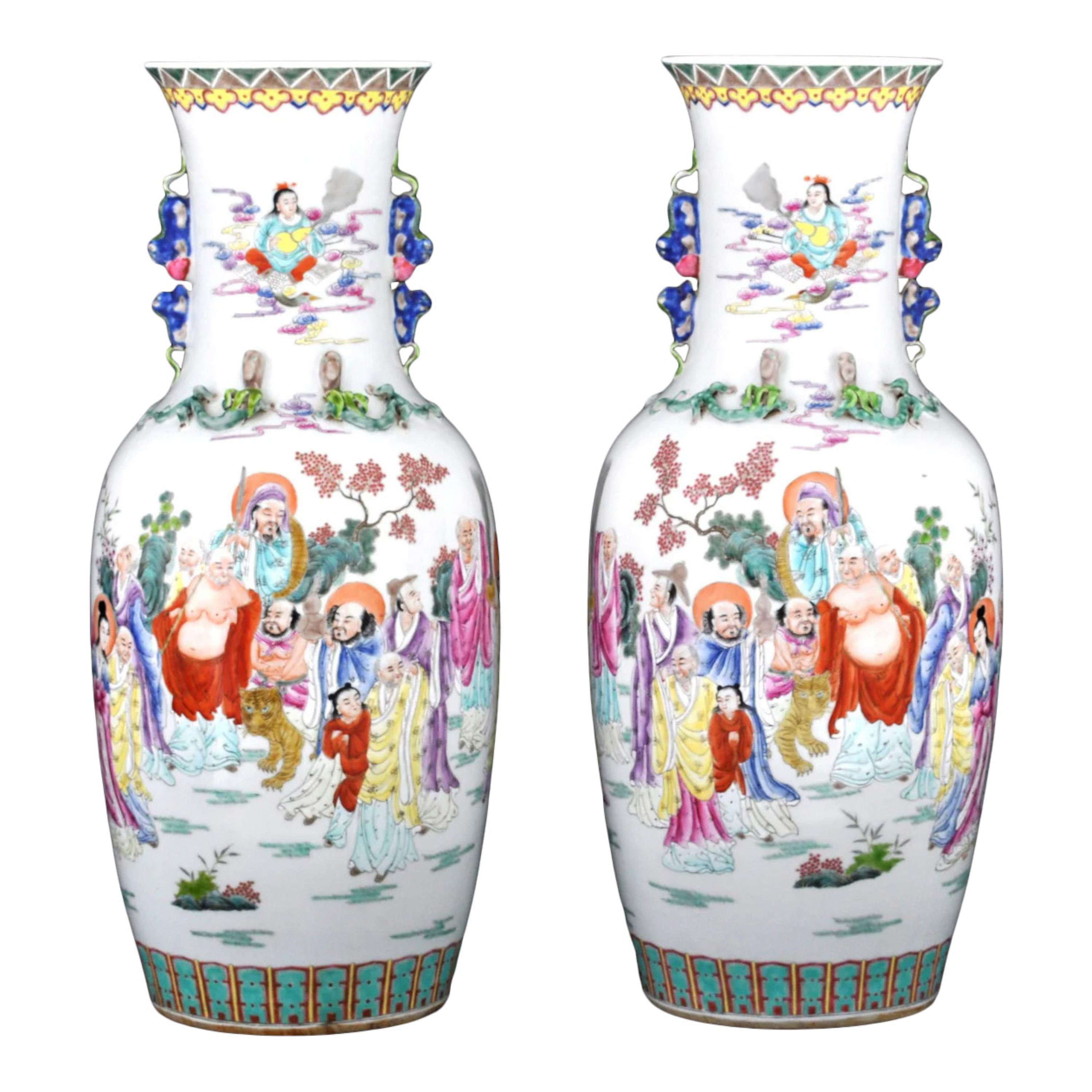 Pareja de jarrones monumentales de porcelana rosa de finales de la dinastía Qing. 
Los jarrones tienen forma de balaustre con asas aplicadas modeladas como dragones; cada jarrón es muy fino.  pintado a mano con escenas policromadas de figuras