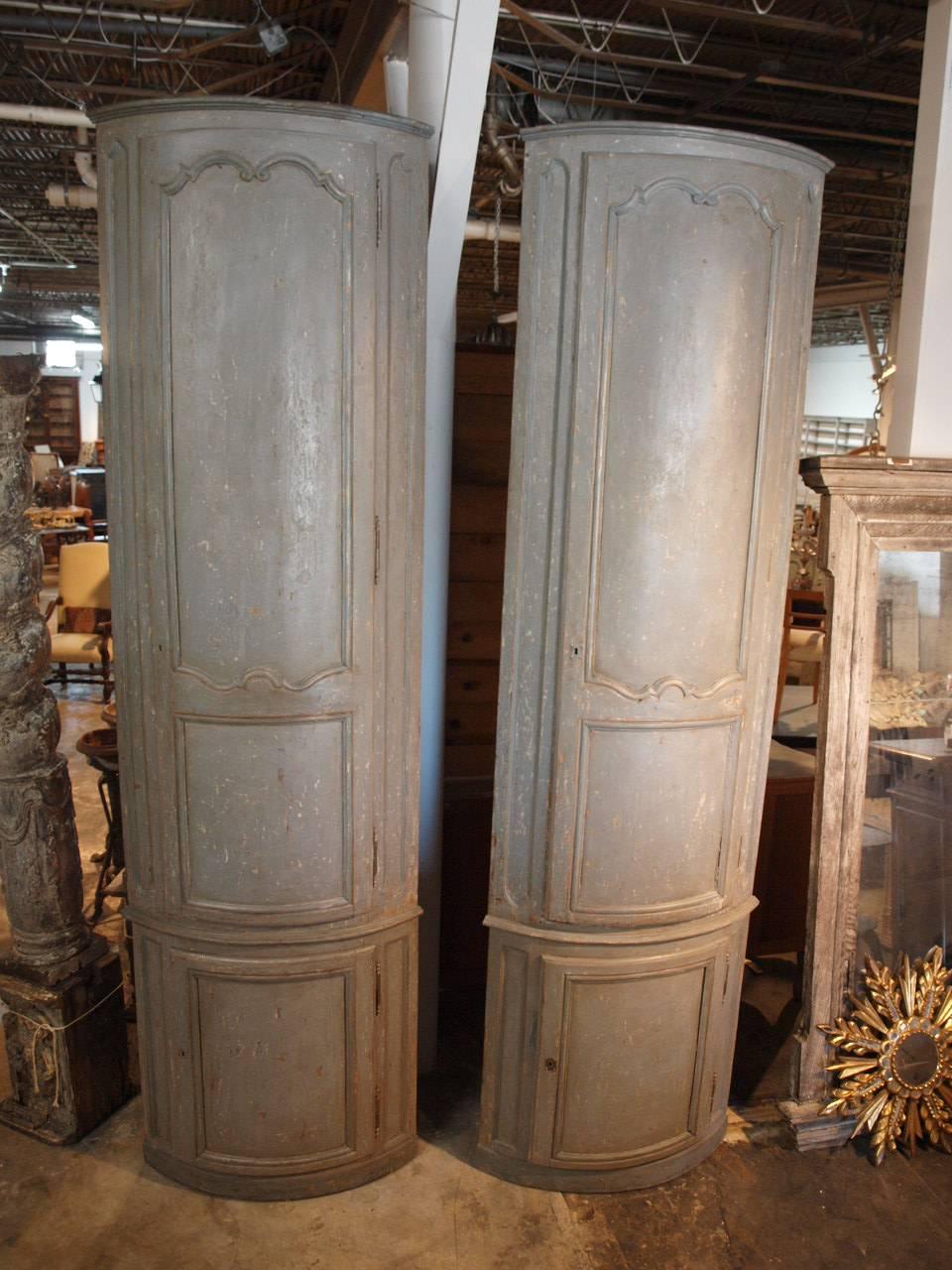 An outstanding and monumental pair of 18th century French corner cabinets from Pau, France. Their tremendous scale makes these pieces indeed remarkable. Wonderful painted finish with rich texture in soft hues of grey. Ample shelving to the interior.