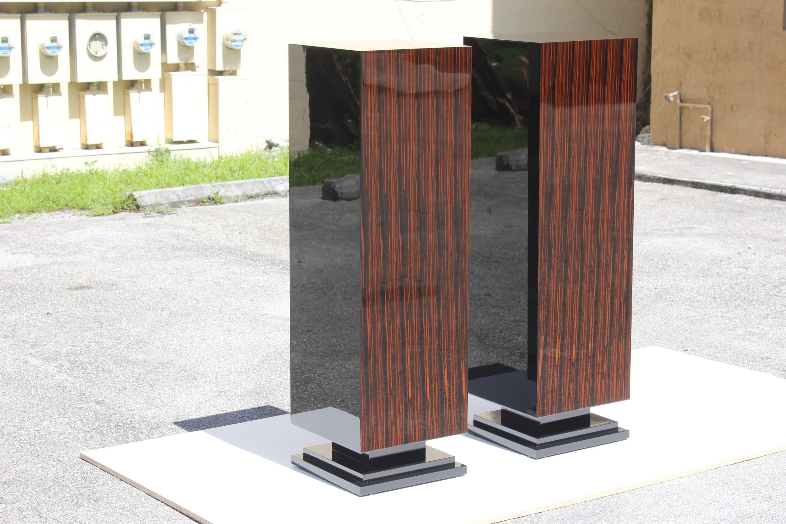 Beautiful pair of French Art Deco exotic Macassar ebony pedestals, circa 1940s. Square geometric bases. These pedestals are Macassar ebony and black lacquer, high-gloss finish and they can be appreciated from anywhere in a room. Newly refinished and