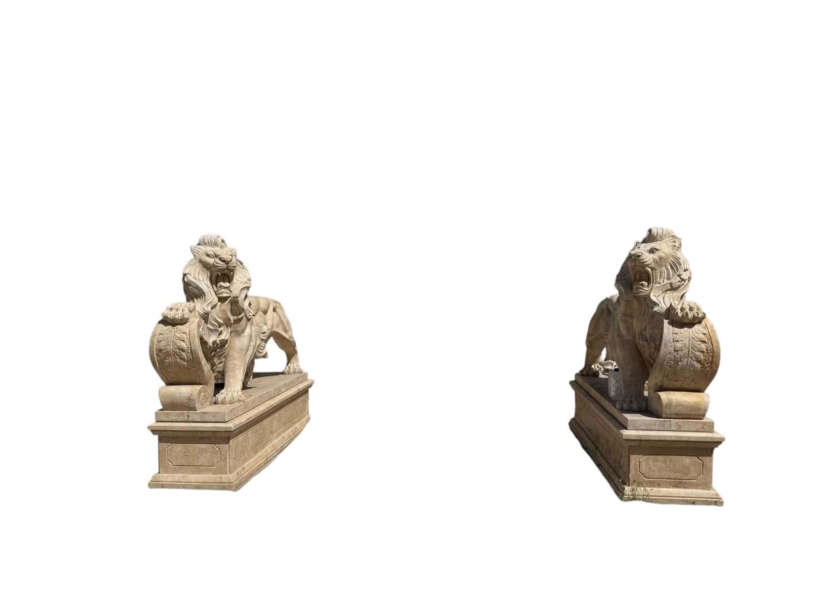 Spectacular and monumental pair of lions, hand-carved in Italy during the 20th century from solid travertine marble. These majestic sculptures feature powerful poses and finely detailed manes, capturing the strength and nobility associated with